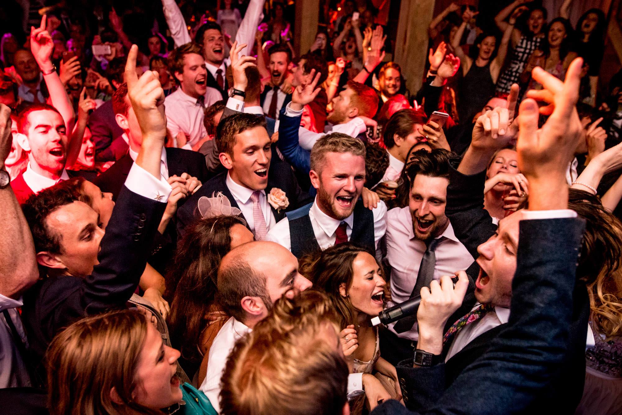 Professional photograph of a crowd singing during a wedding reception