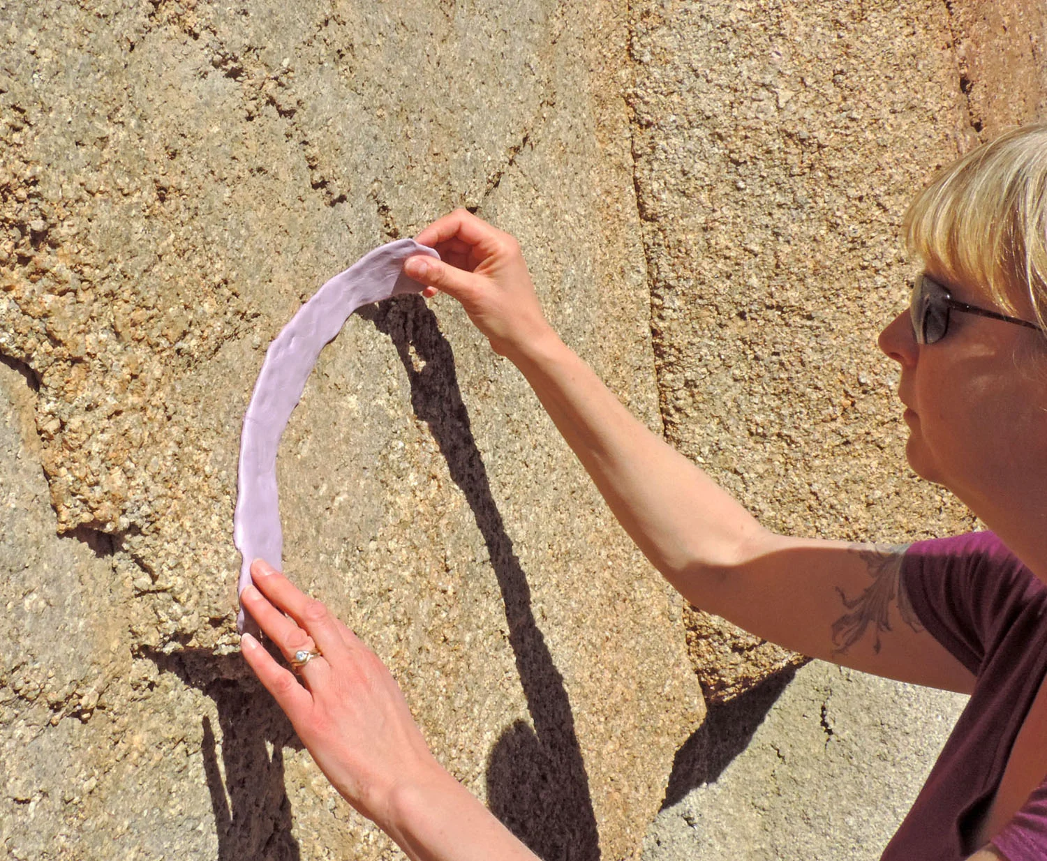 Carefully removing a silicone bracelet mold from a granite wall at Joshua Tree National Park, California. 