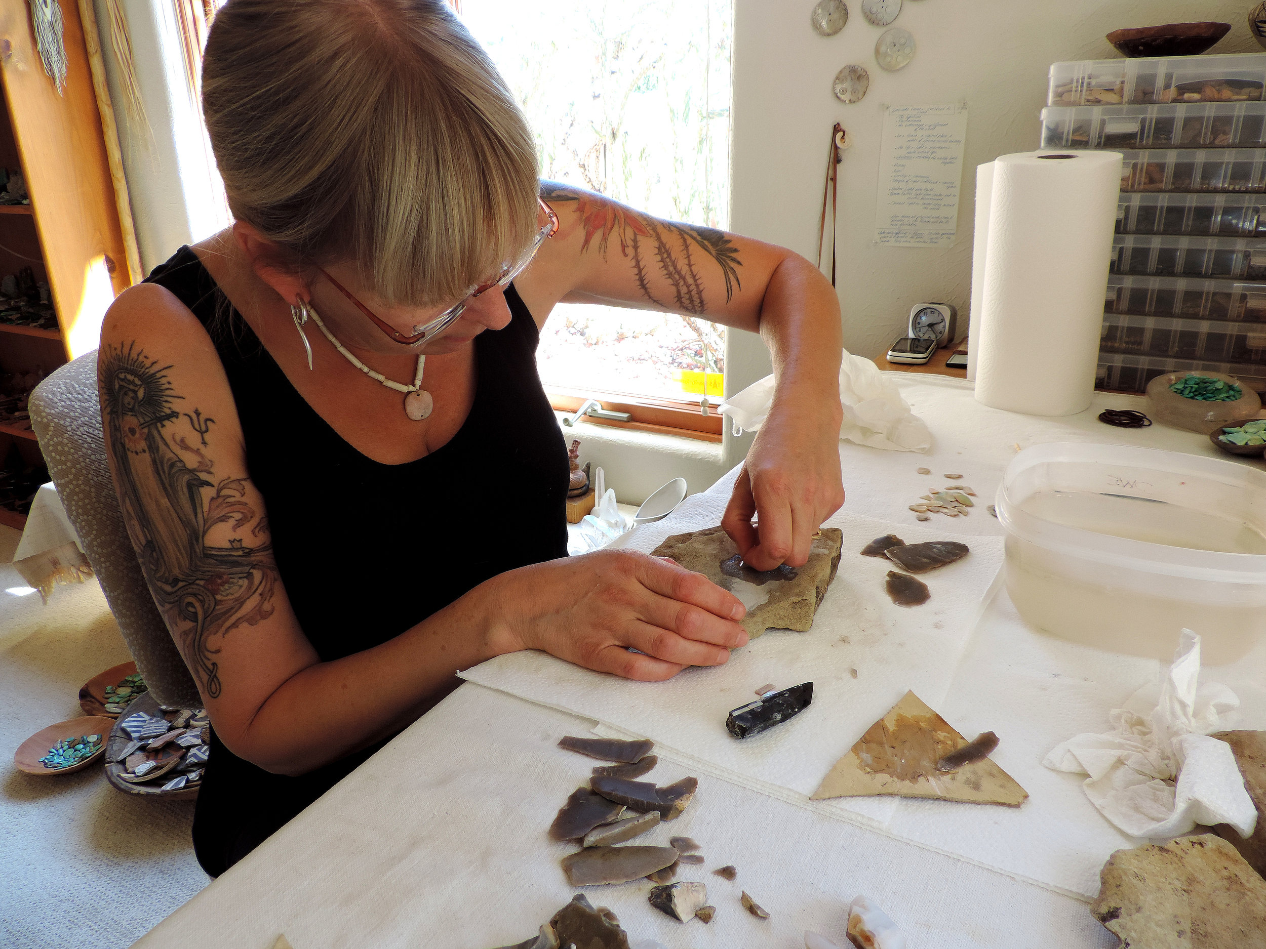 Ancestral Pueblo techniques in the studio: grinding abalone tesserae on sandstone for inlay in a jet pendant.