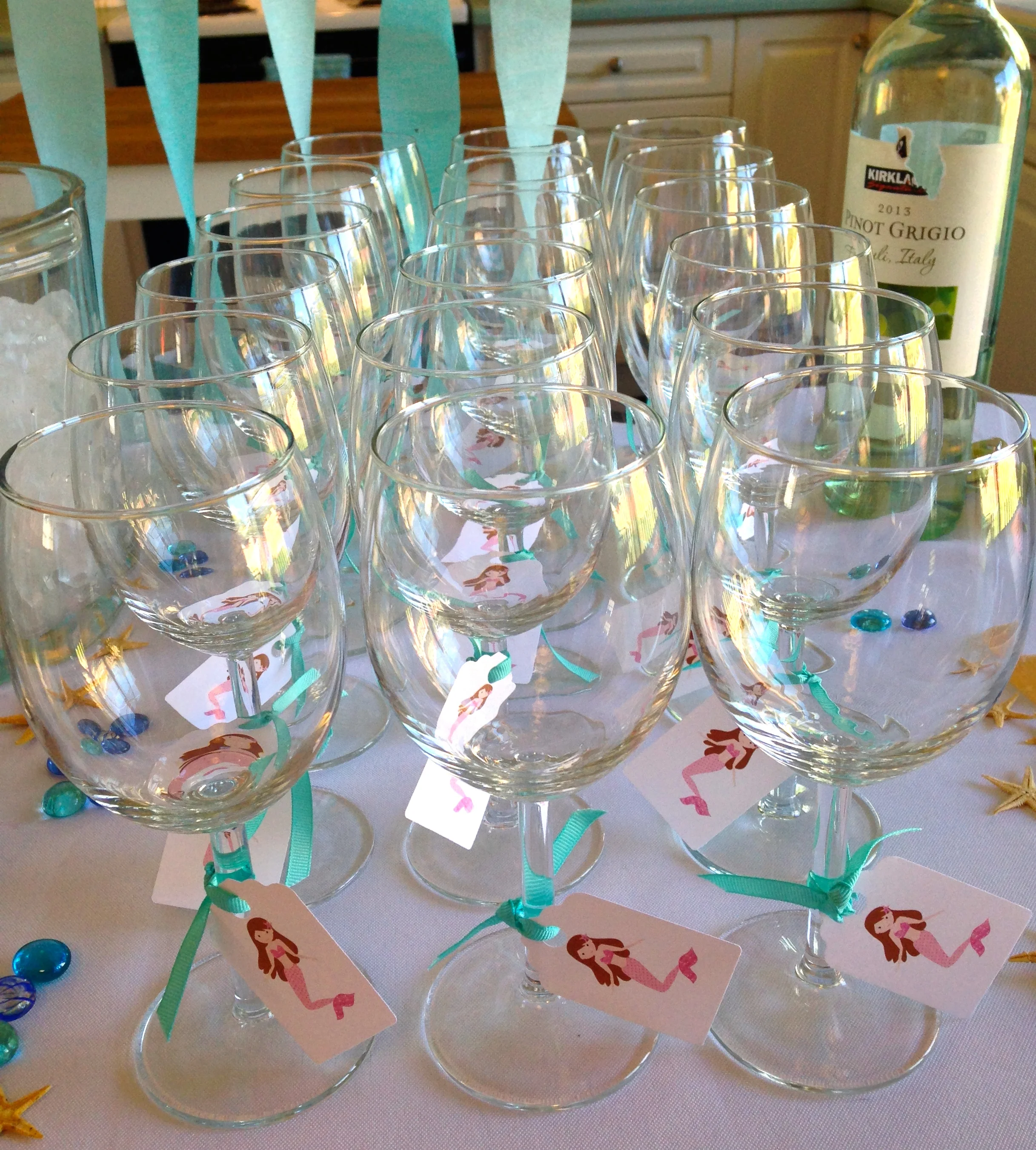 Ikea wine glasses with mermaid graphics purchased from Petittatti on Etsy printed on card stock, then punched out with a dye cutter.