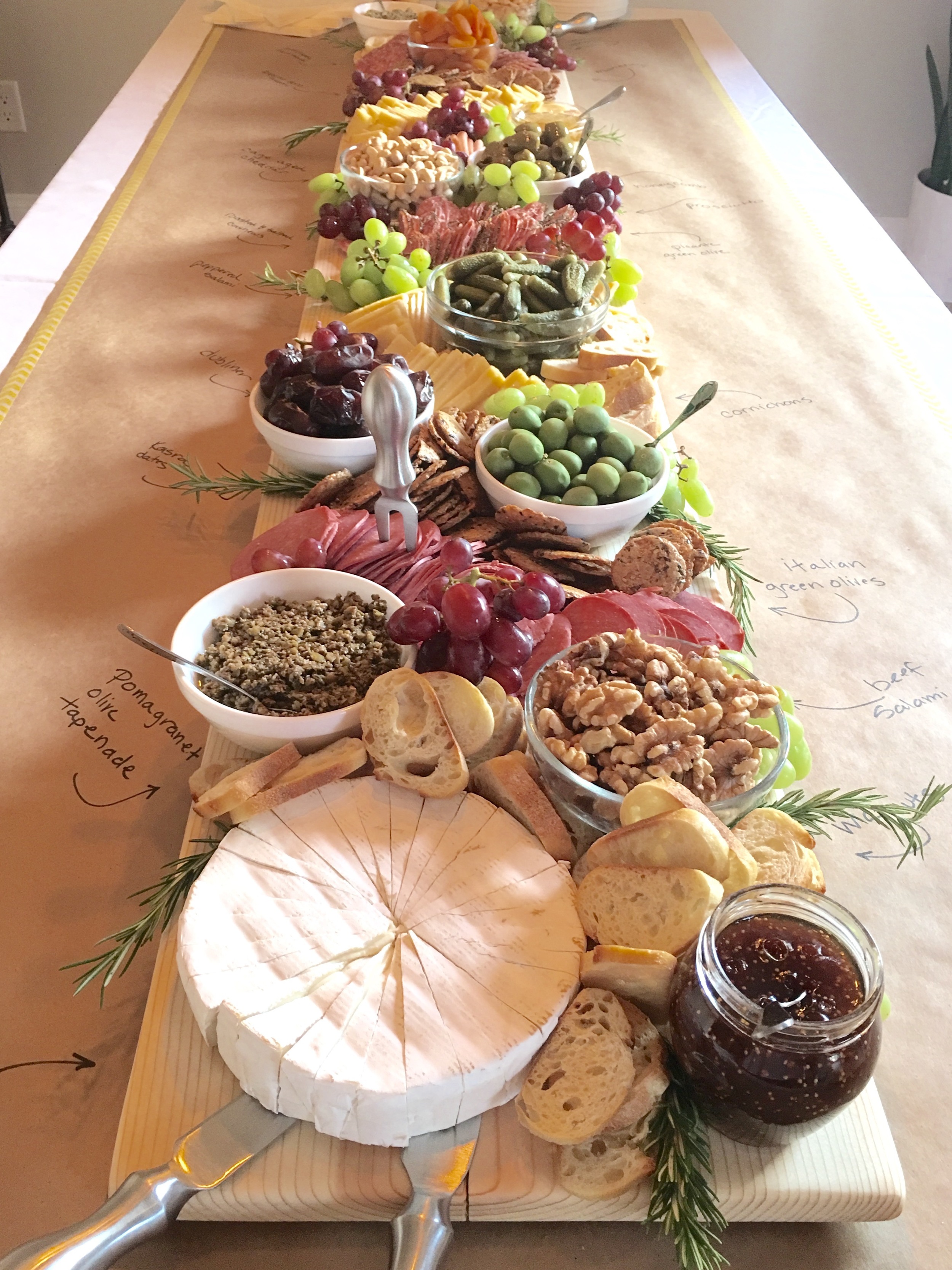 Next I placed all the meat and cheese. I decided to pre-cut all of my cheese- for a tidy presentation and so guests could quickly fill their plates. I filled in all the holes with bread, crackers, grapes, rosemary and candles. The idea is for the board to appear abundant and overflowing. 