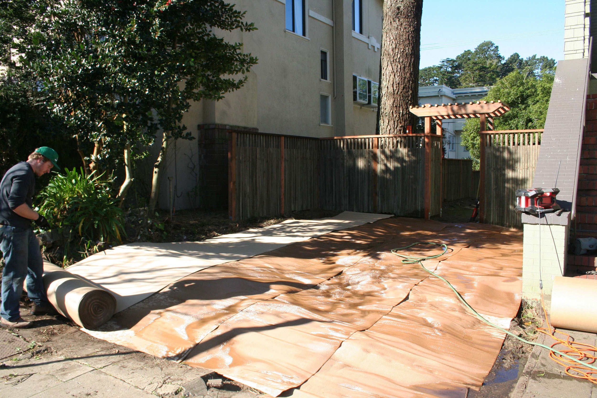 Rolls of cardboard are then laid out over the existing soil. This prevents weeds in the short term while the plants have time to establish.