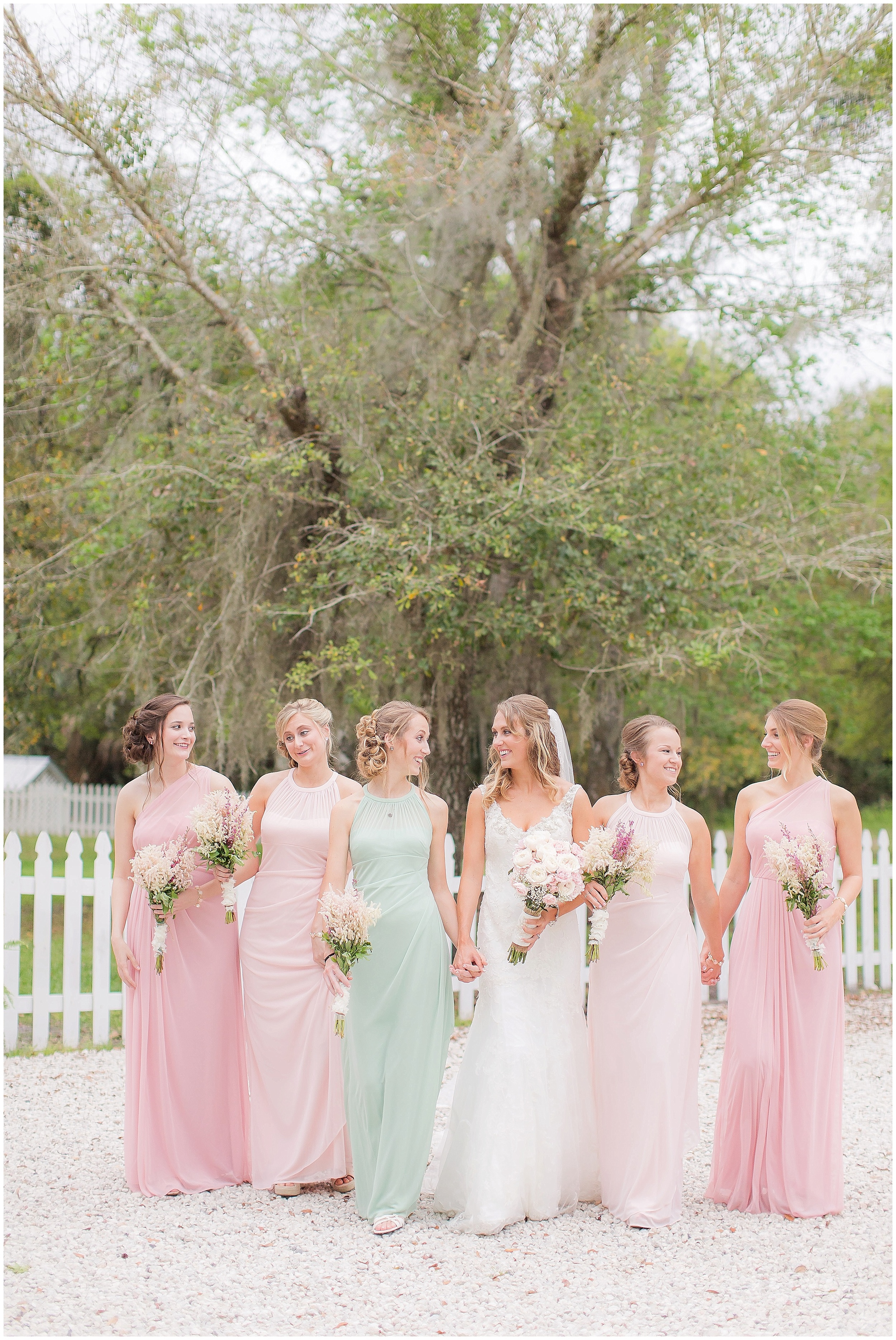 The Happy Just Married Bride with Her Bridal Party in Pink and Green Dresses. 