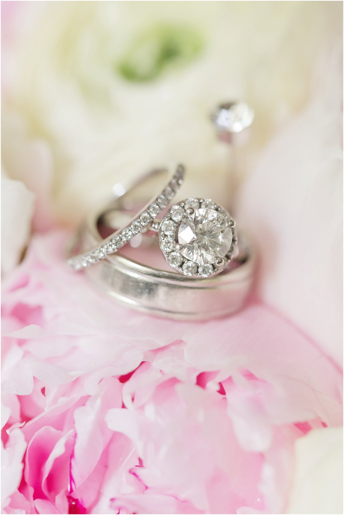 Wedding Bands and halo engagement ring on peony bouquet 
