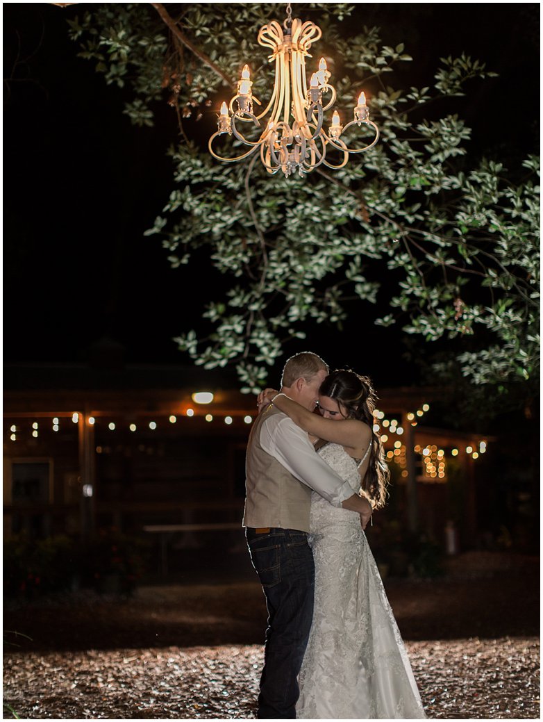 Bridle Oaks Bride and Groom Posing Under Chandelier at Night
