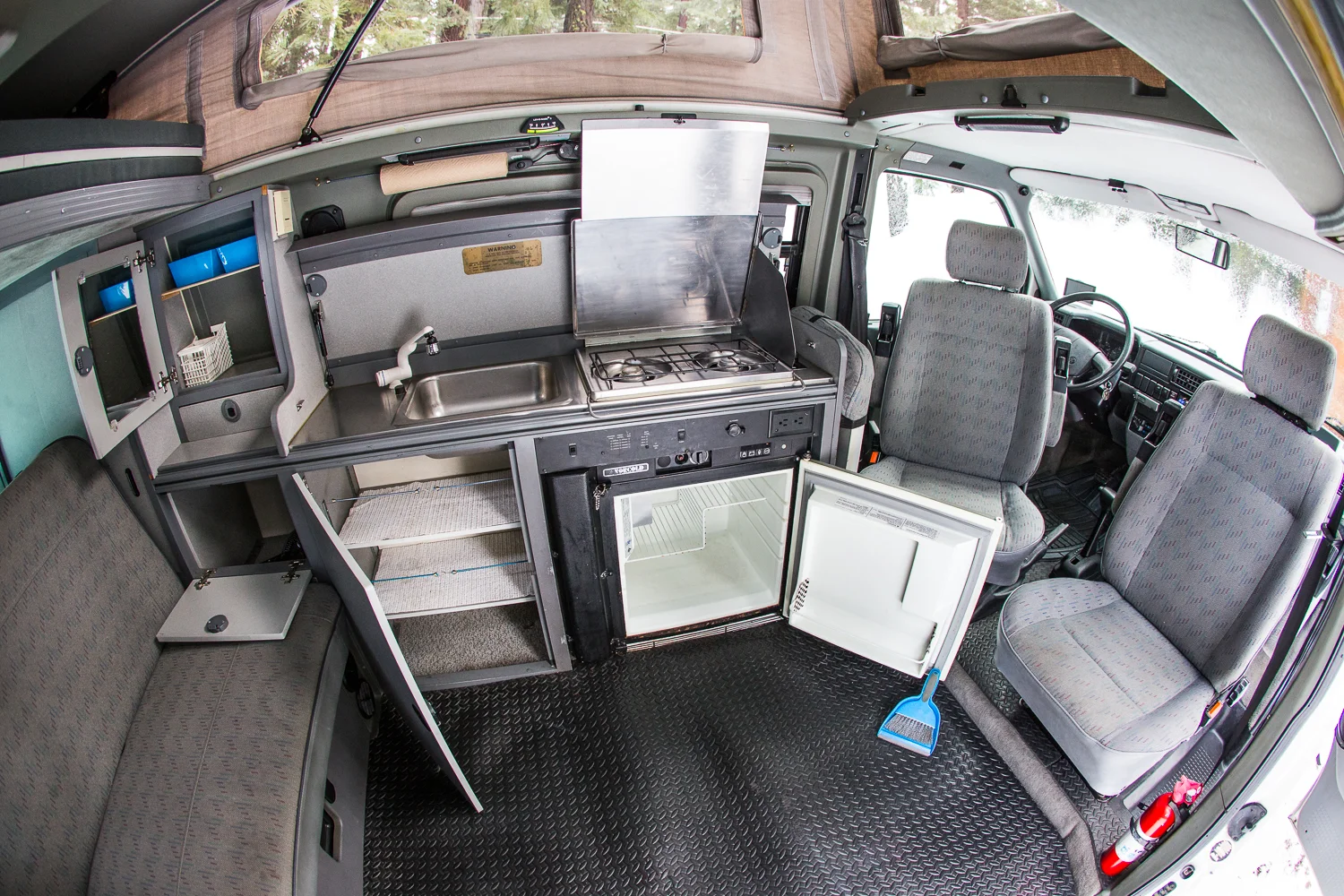 Full mini RV here: back area has closet, storage under back trunk, hidden secret storage under bench, left you see mirror and shelves, under it is another storage cabinet, under stainless steel sink is a lot of shelving, next to it a 2-burner stove top, and good sized fridge. 2 tables easily set up for dining or desk space. There's also a great organizer that hangs on back of passenger seat. The space is extremely well designed to maximize every inch, making a minivan sized vehicle function like a large camper.
