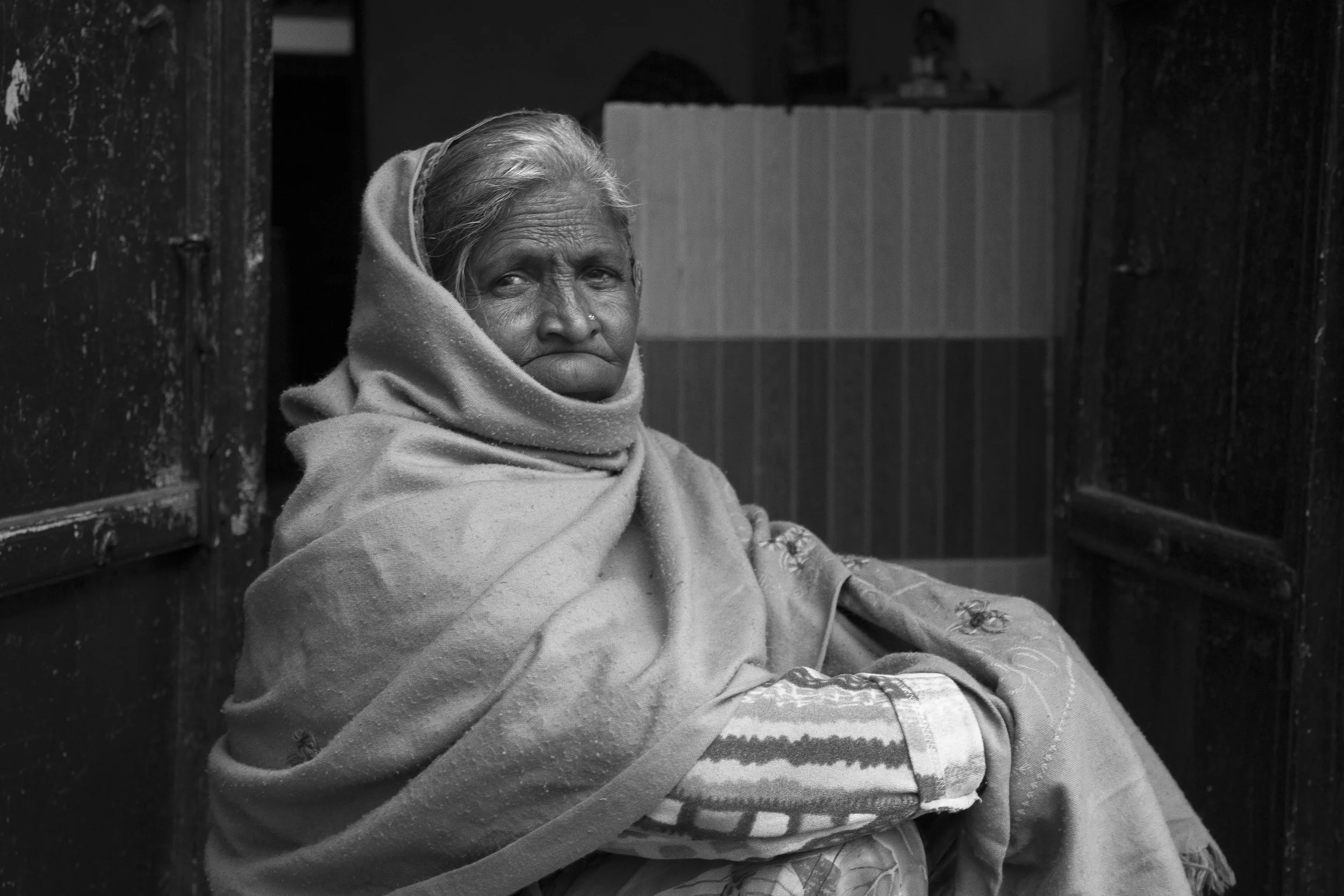 Old woman relaxing outside her house. Udaipur, India.