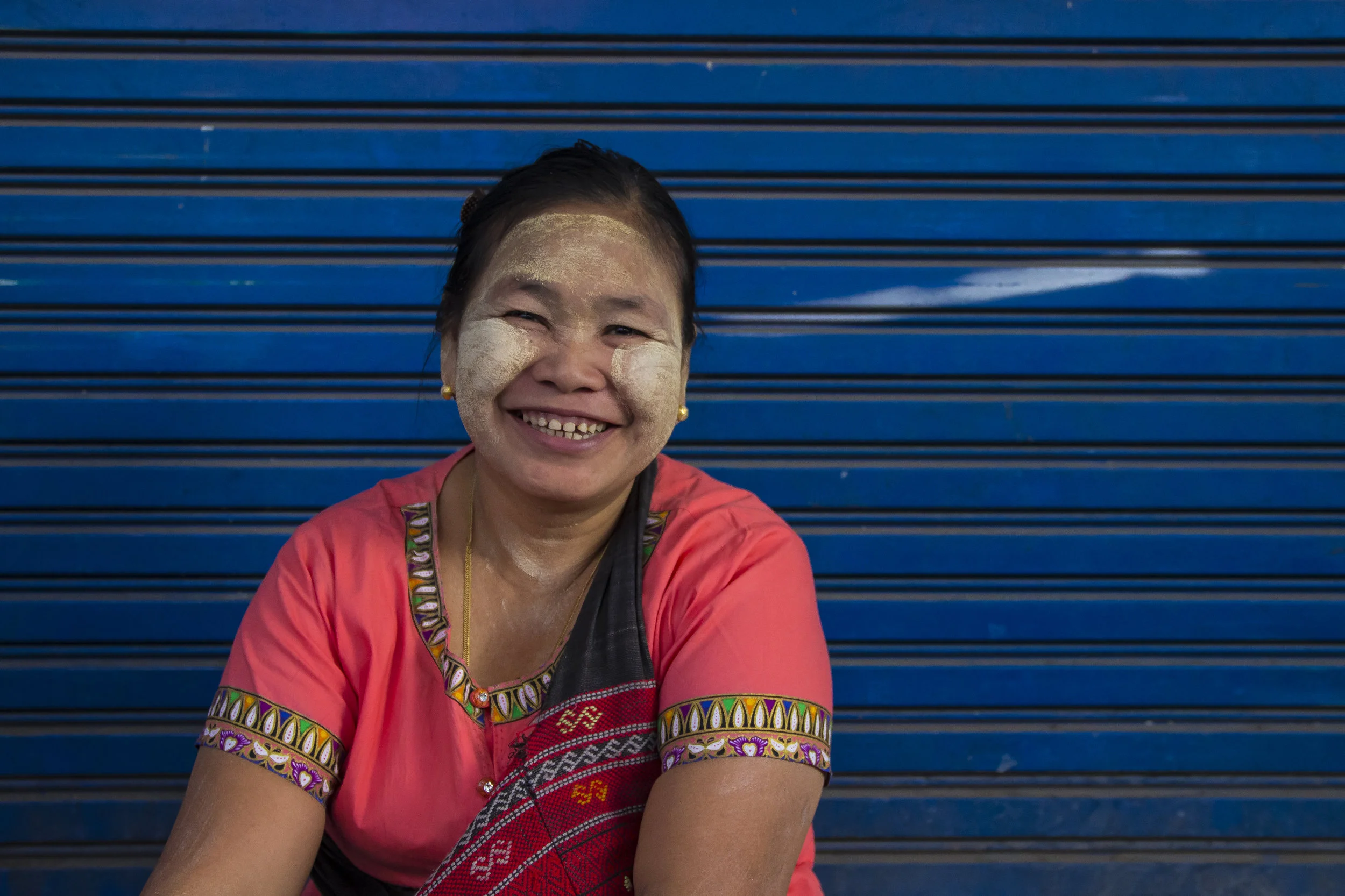 Smiling shopkeeper with distinctive thanaka smeared across her cheeks. Yangon markets, Myanmar.