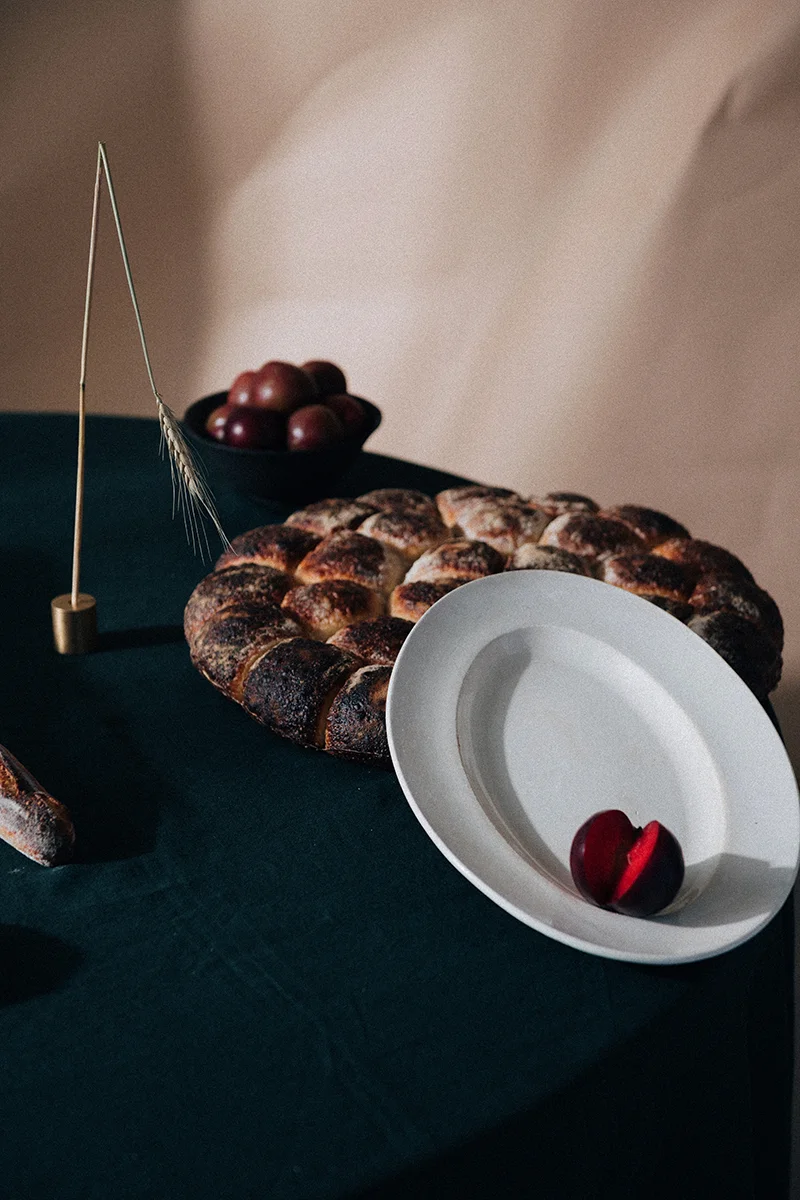 Still life photograph for In Bed Linen editorial studio featuring fruit and pottery on a tabletop.