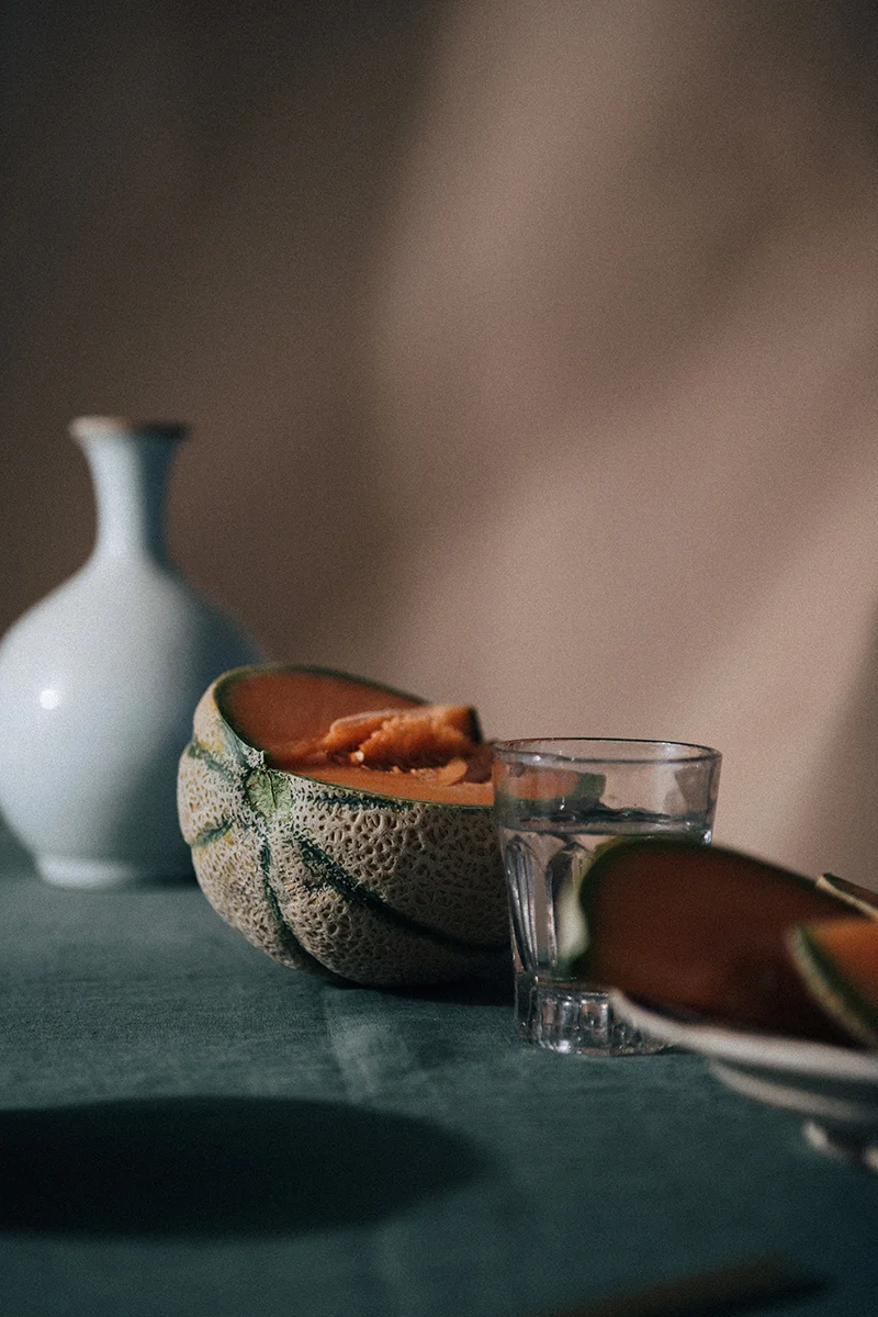 Still life photograph for In Bed Linen editorial studio featuring fruit and pottery on a tabletop