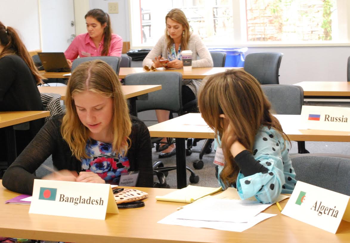 Audrey Hankins (left) and Bethany Blakeman (right), representing Bangladesh in the General Assembly, collaborate on a proposal to address the effect of forced migration caused by climate change.