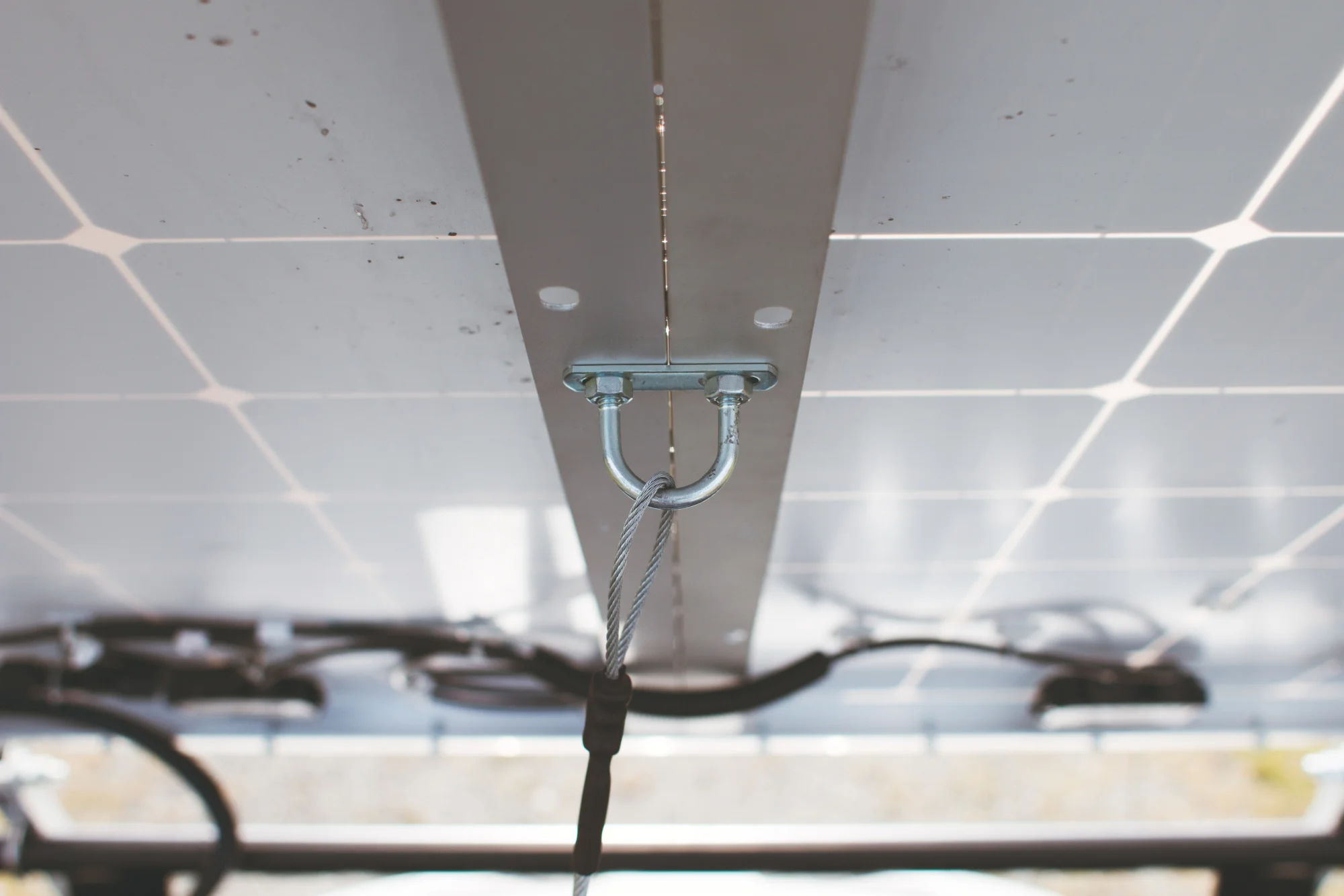 The U bracket in the middle has a vinyl-coated wire attached. This prevents the solar panels from moving past a 90-degree angle.