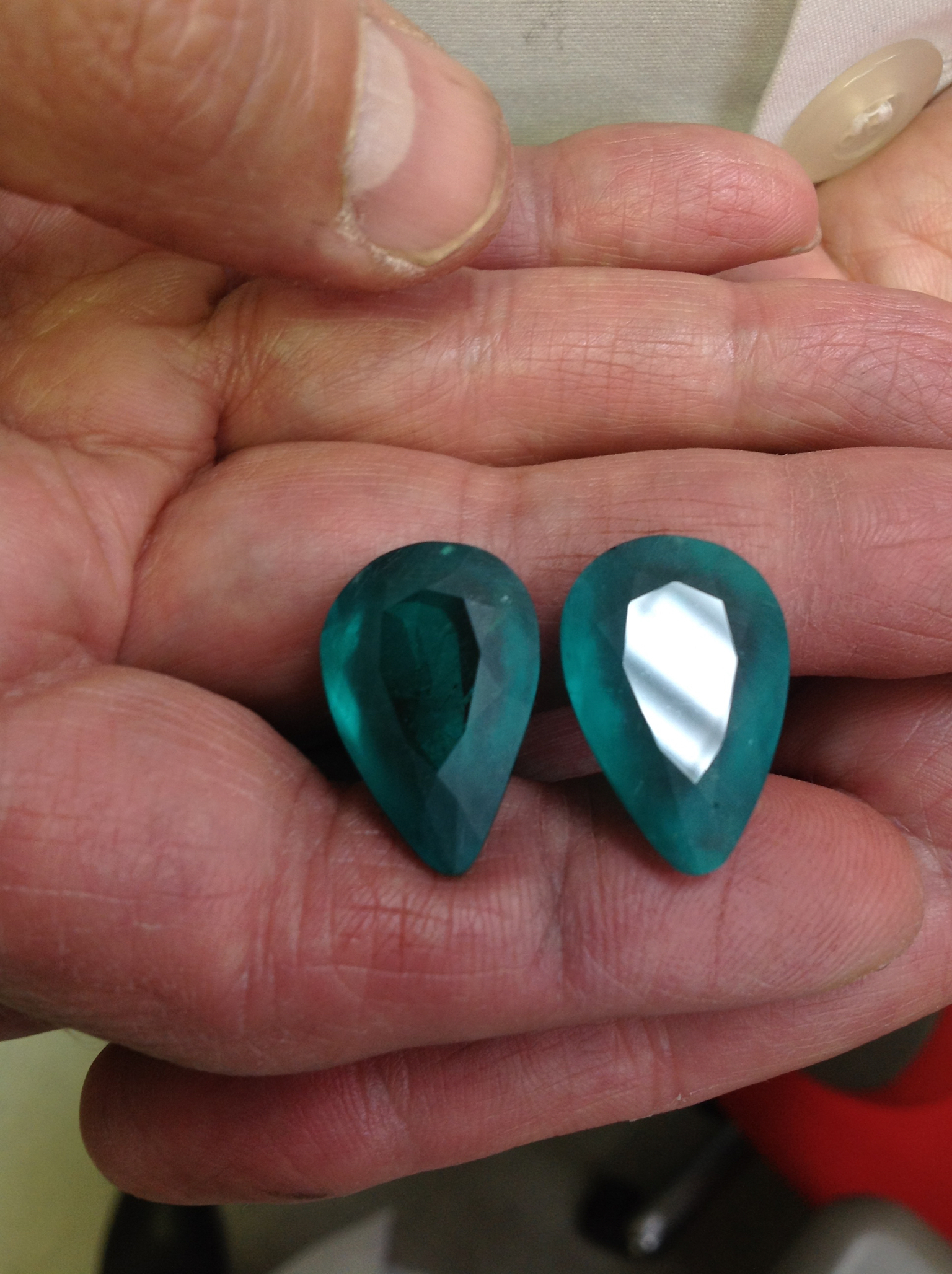 Tops are cut and ready for polish before sending this matched emerald pair to auction