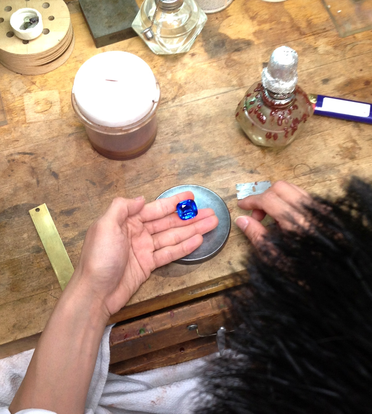 The polisher inspects his work on a 38 carat sapphire