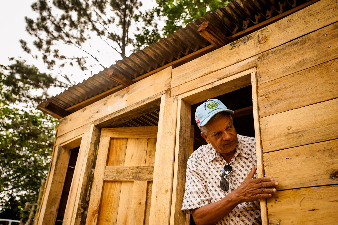 Carlos Bonilla of ADESJO Natural Resources department examines the wood used for the construction of this shed, which will serve as an office at the local sustainable lumber yard in the village of Derrumbado. Bonilla has worked with ADESJO for over 25 years, and is responsible for all the projects involving the natural resources in the province of San José de Ocoa: reforestation, irrigation, soil conservation, to name a few. Under his supervision, he estimates to have planted more than 50,000,000 trees in the area. Dominican Republic, June 30, 2014. Copyright © 2014 Art Zaratsyan
