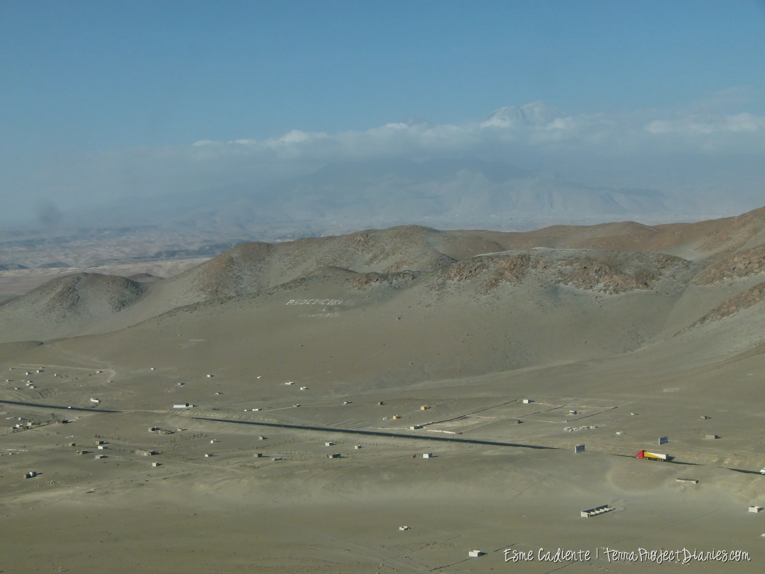 A strip of highway, accompanied by shacks here and there, slice through the desert in Southern Perú.