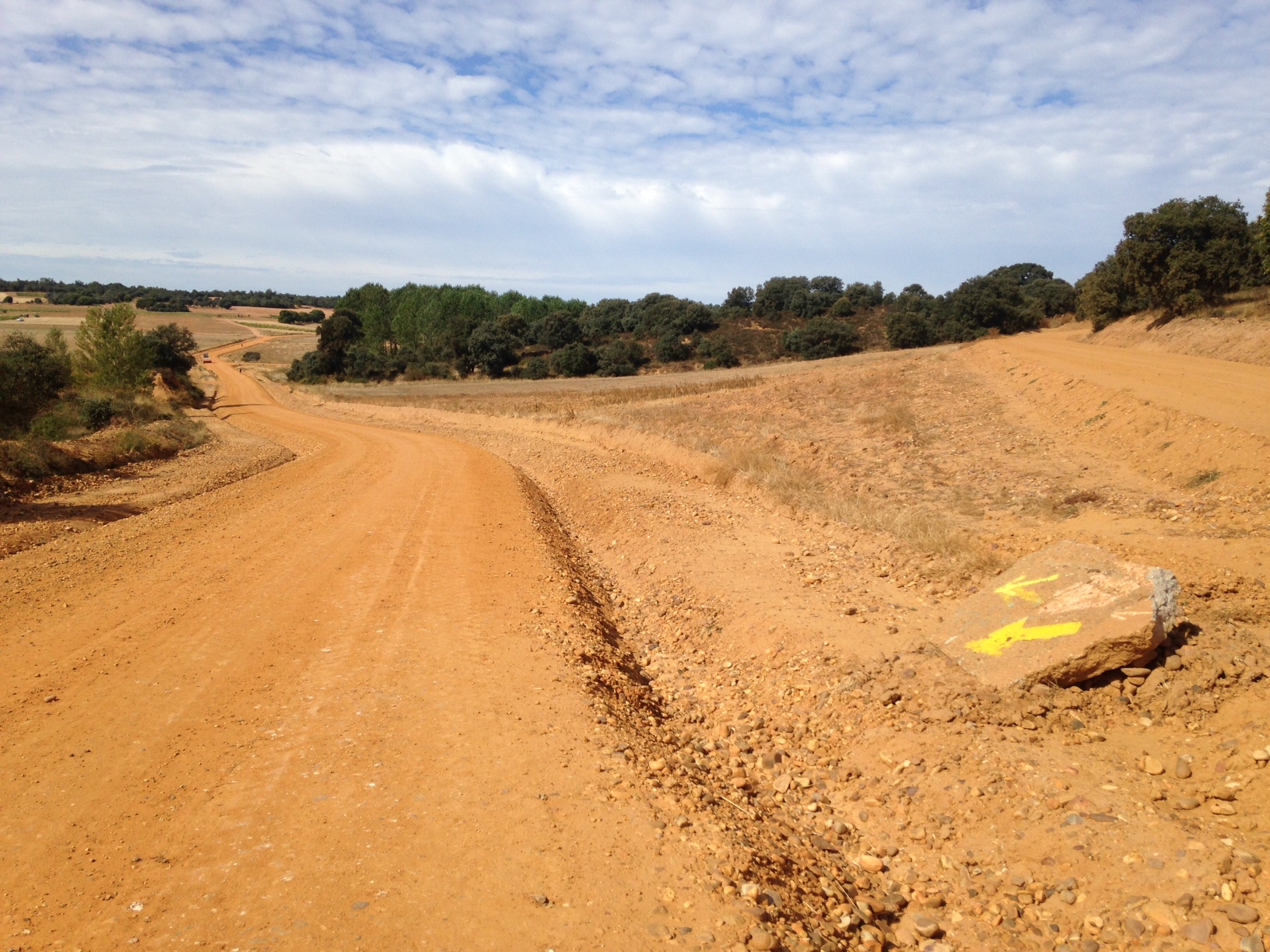 Yellow arrows mark the dusty path toward Astorga.