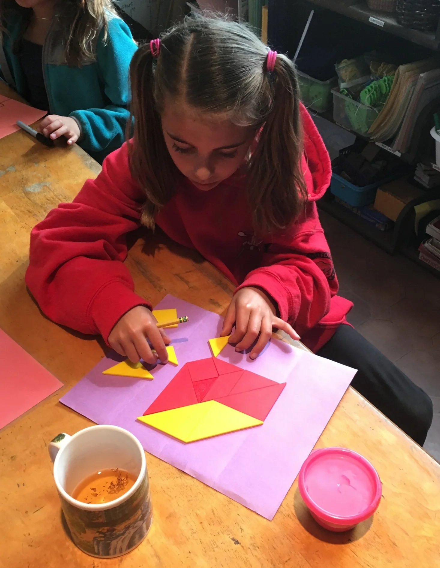 Ella creates a tangram puzzle using 2 sets.  