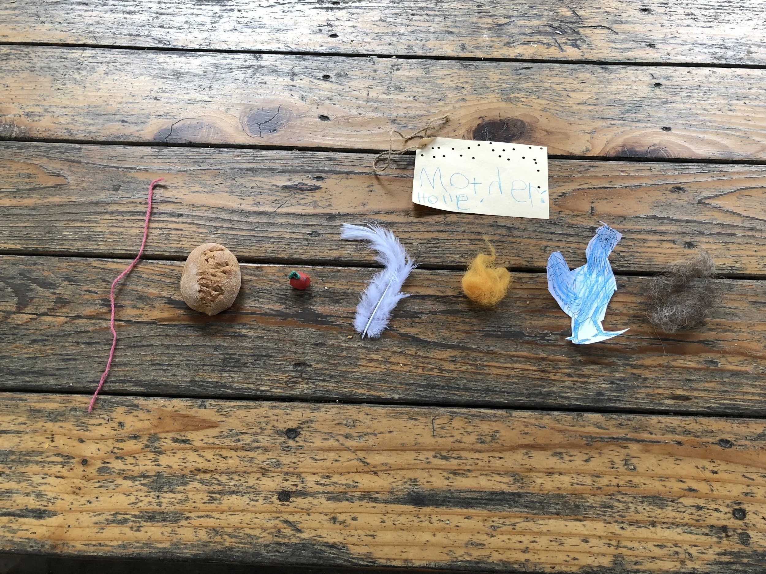 The yarn, representing the spindle and the pricking of the finger. The bread to remind about the oven full of bread that speaks to the girl. A clay apple to symbolize the apple tree dripping with ripe apples. The feather to remind the kids about Mot…