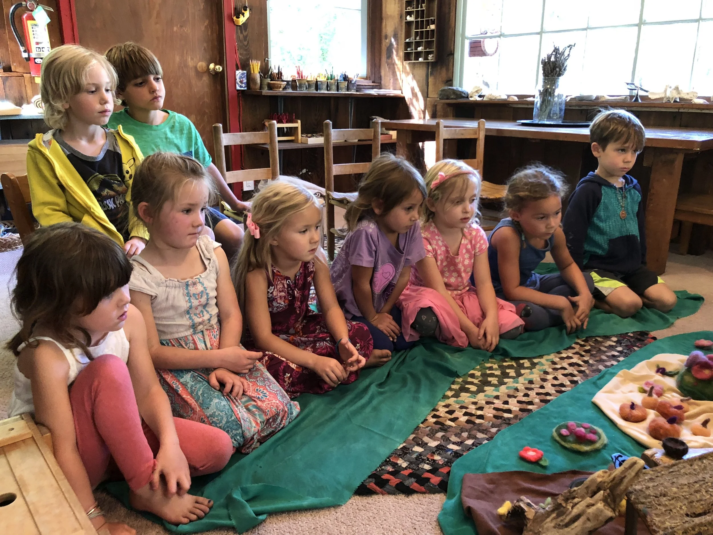 The children are enraptured as Kathleen tells the Magic Tree Elves story, an autumn tale about sharing one’s bounty with others.