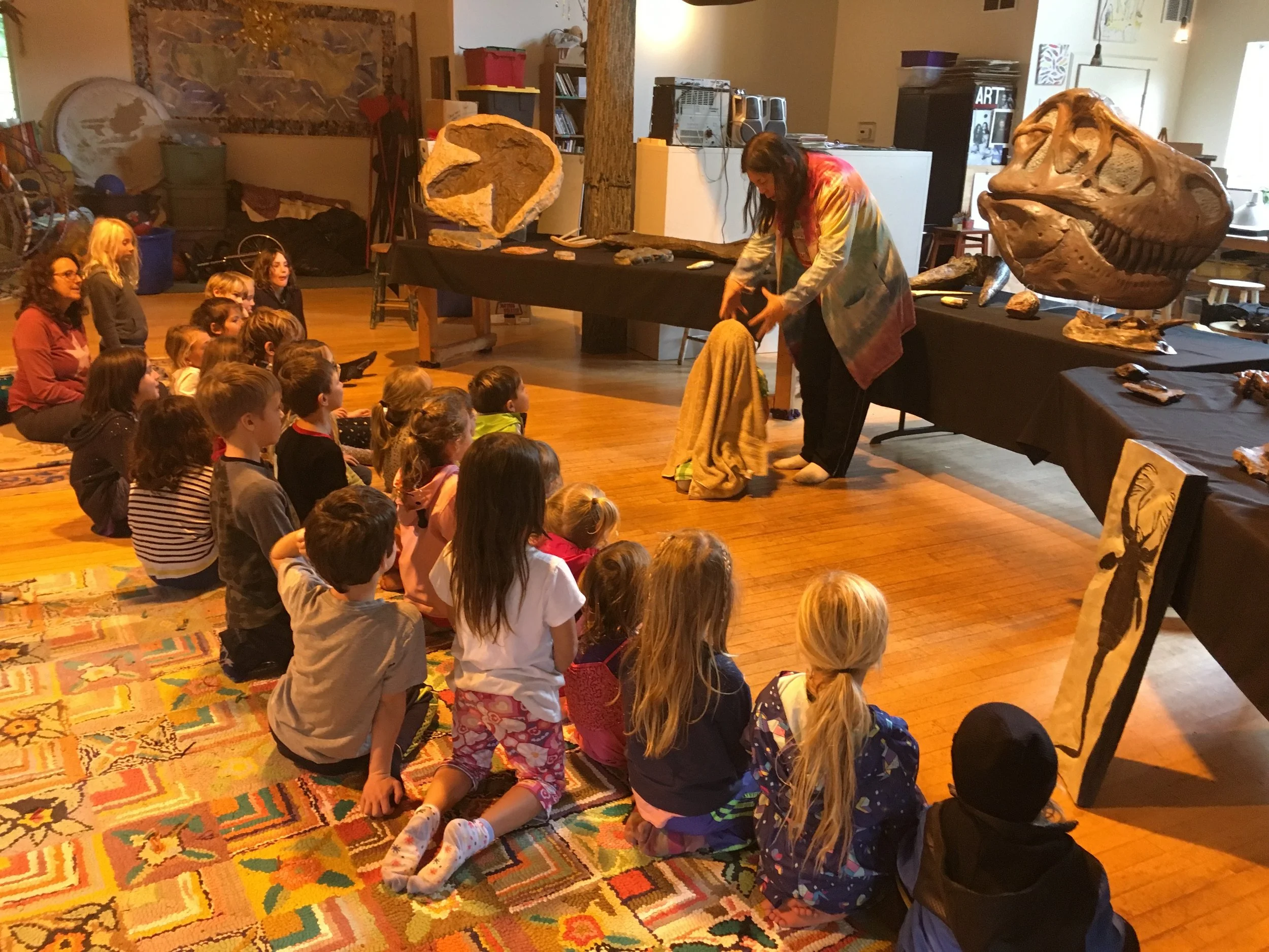 Maxine demonstrating how an egg gets covered with mud and becomes a fossil.