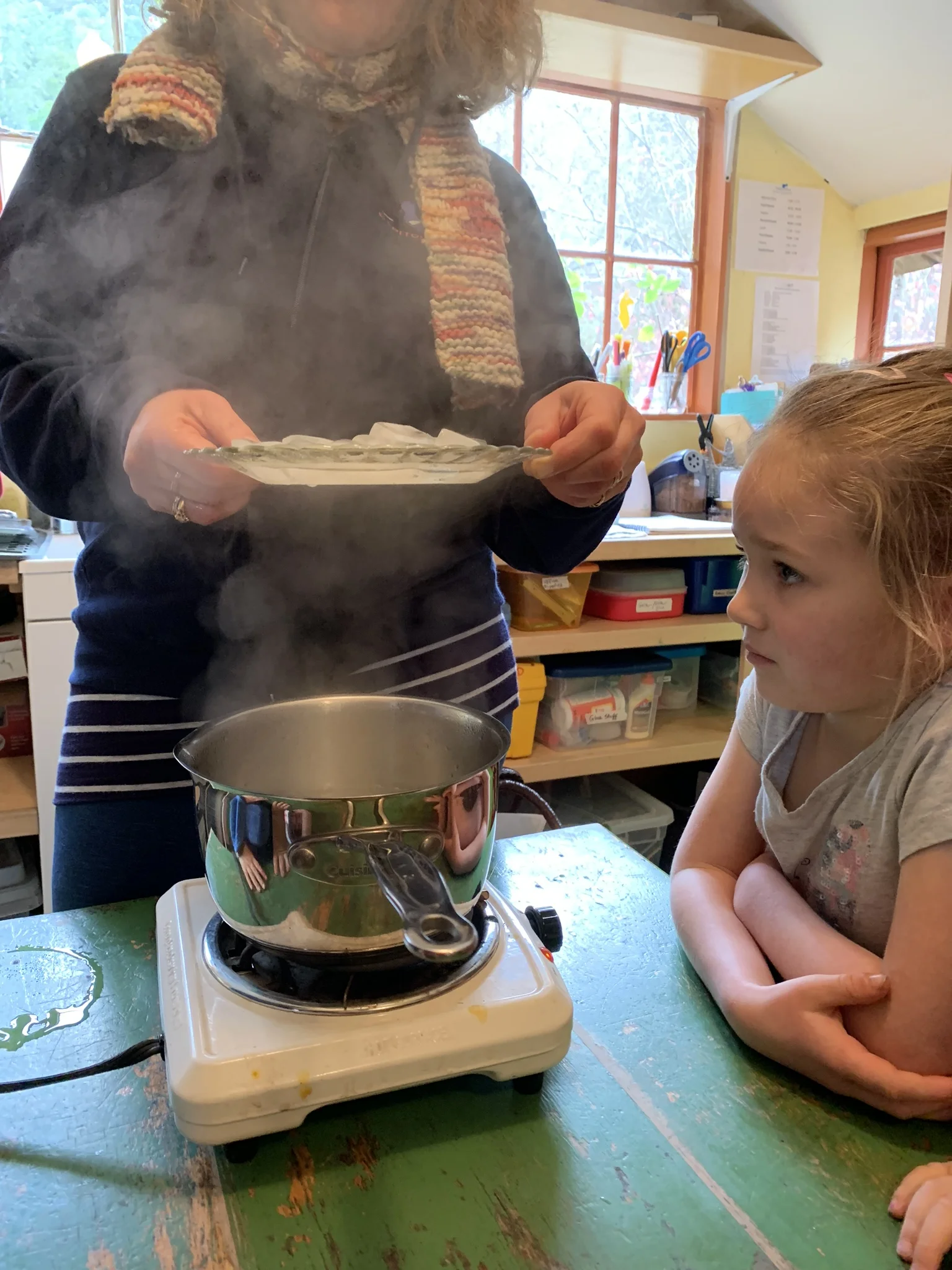 I made it “rain” in the classroom so the kids could see the process of evaporation, condensation and precipitation up close — the hot plate represented the sun heating the earth’s water. They could see the steam rising (evaporation) and then the pla…