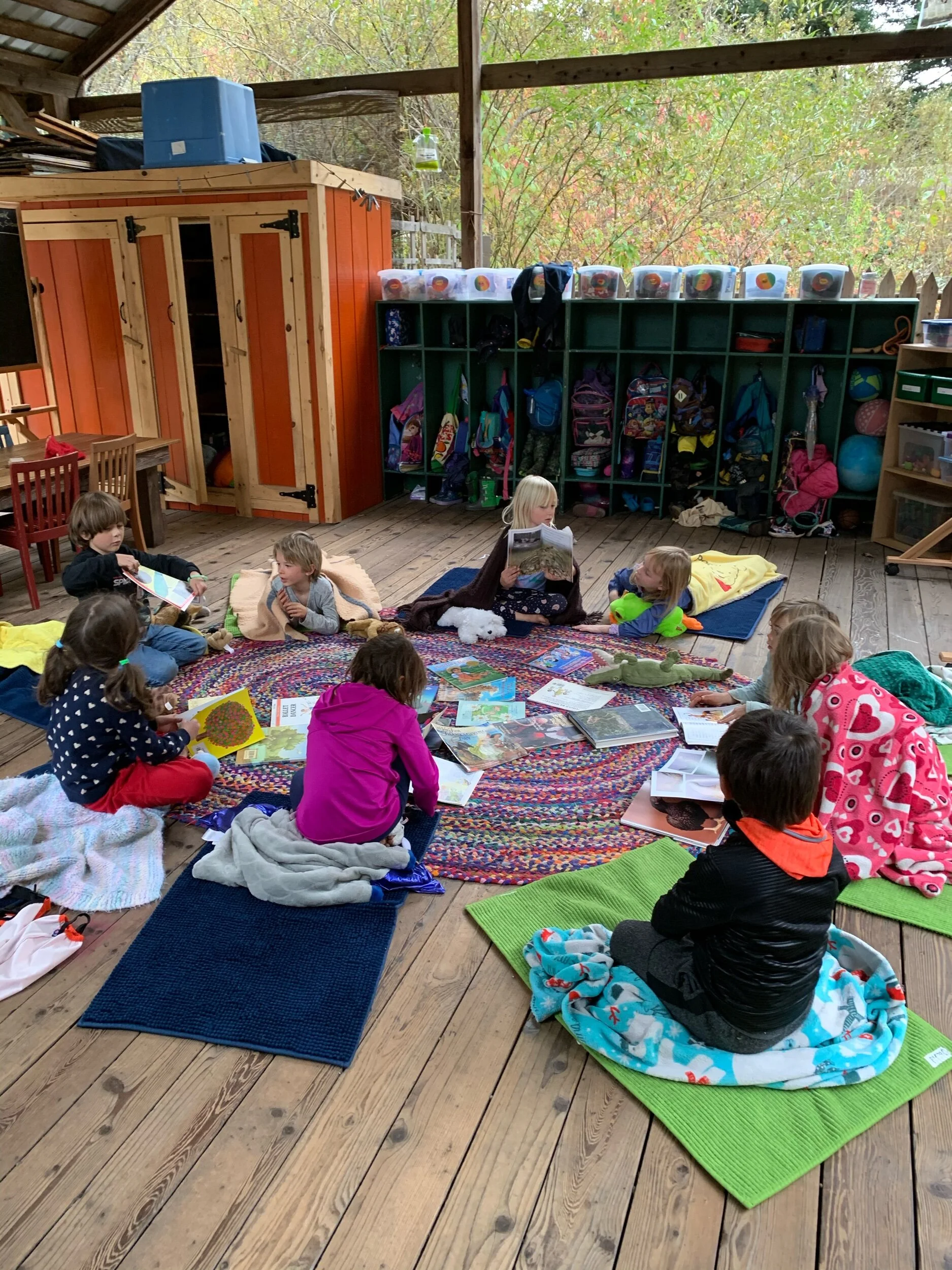 Rest time. The children quietly look through books, share a small snack, hear a story, share news and feelings, the teacher makes announcements sometimes, and then the kids have play time on the deck or continue resting and reading if they prefer.