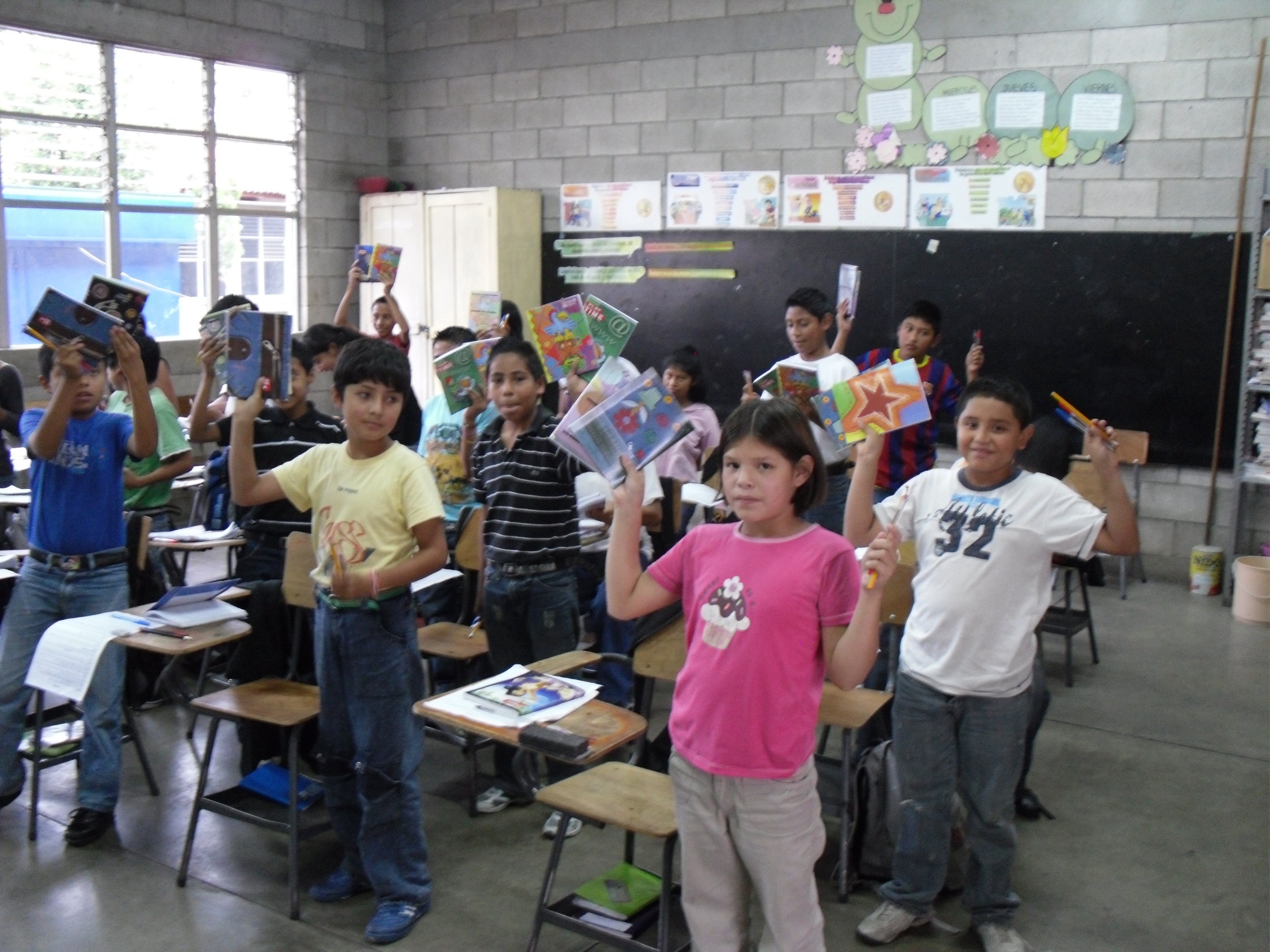 Guatemalan students holding school supplies RWF delivered.
