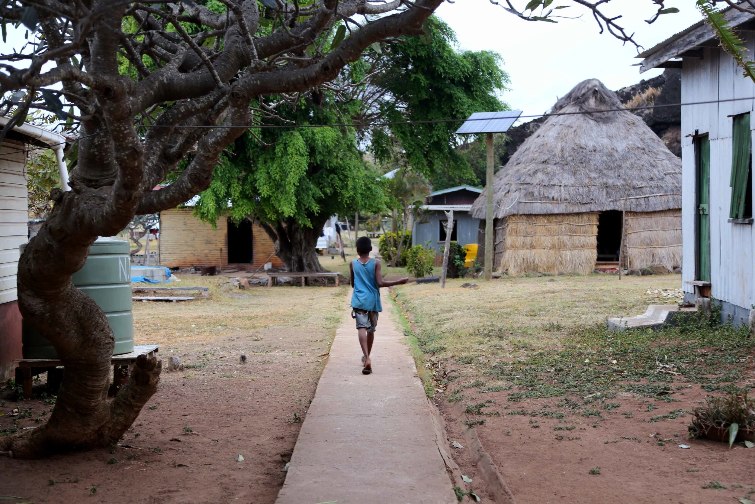 A young boy walks between houses in the Denimanu village on Yadua. 