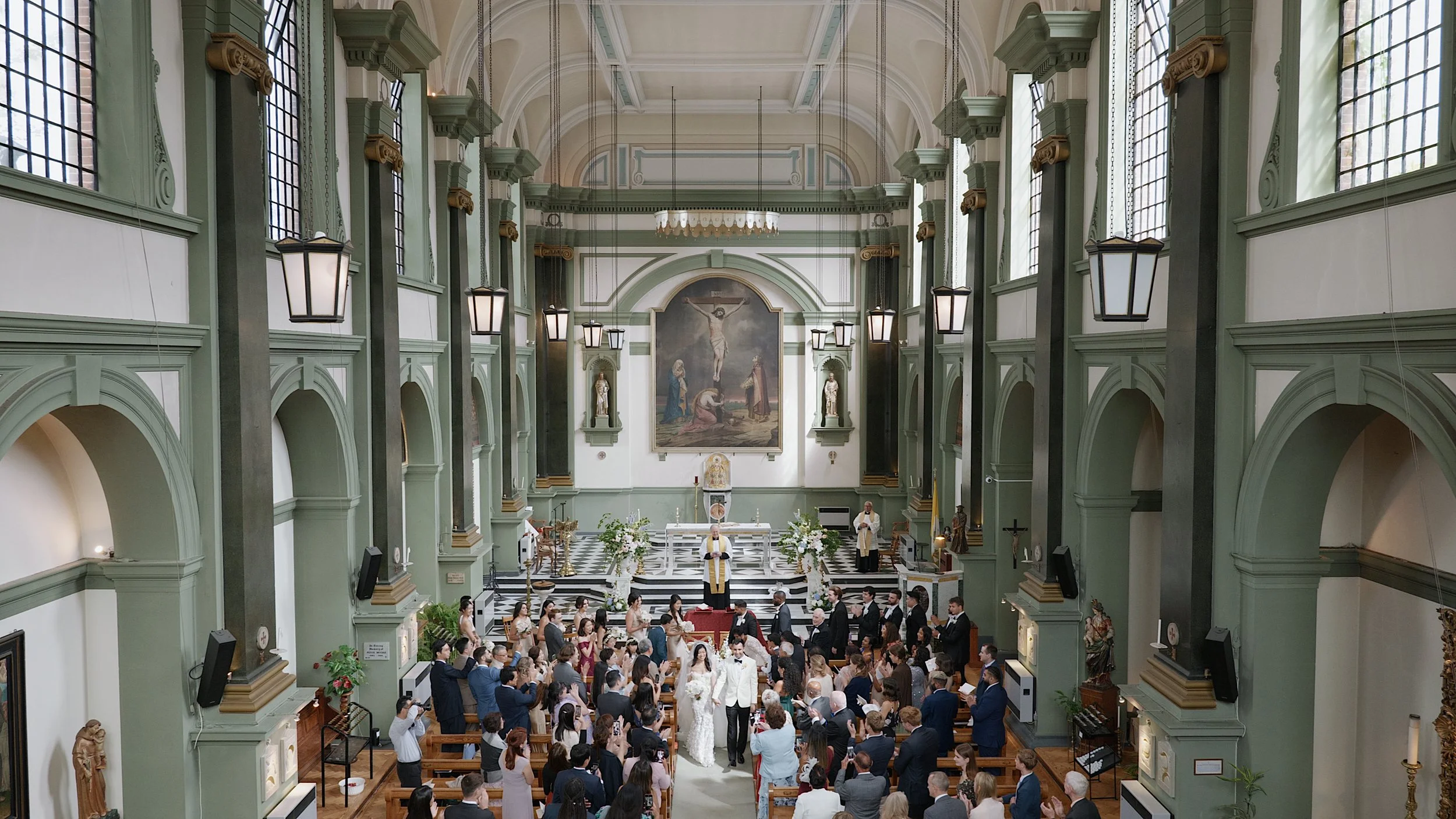 A bride and groom walking down the aisle of a church after their UK wedding ceremony, with guests in the pews