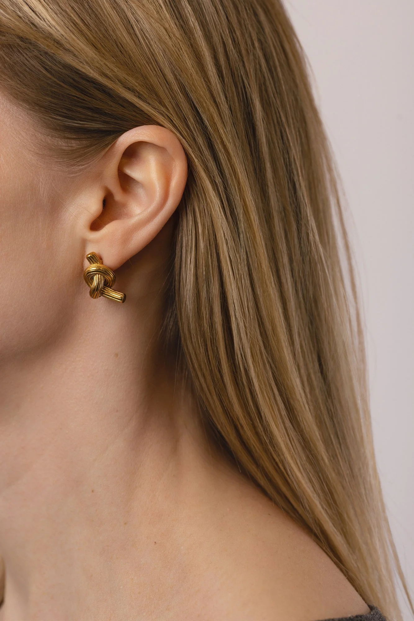 House Thirteen Knot Stud Earrings worn on model, waterproof gold knot stud earrings