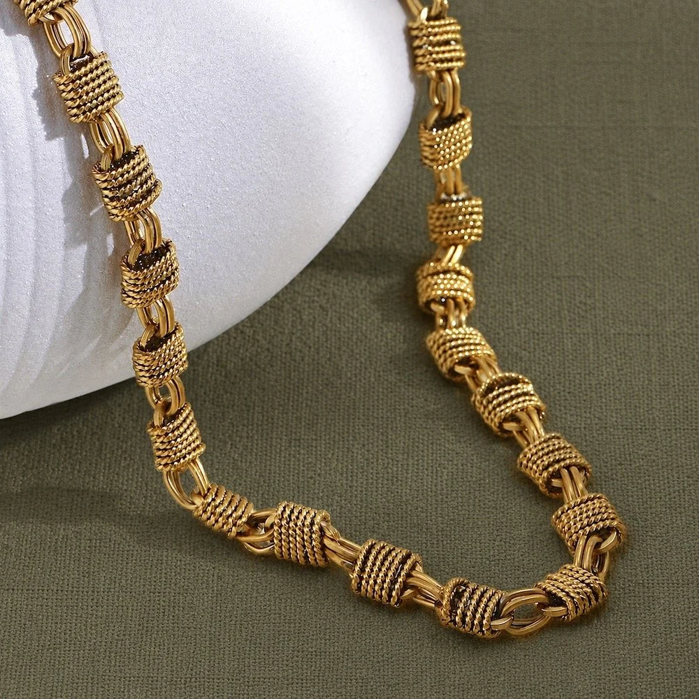 House Thirteen Woven Chunky Chain Necklace styled on sage green fabric. Gold chunky woven link necklace works well as a statement or layered. waterproof and suitable for daily wear