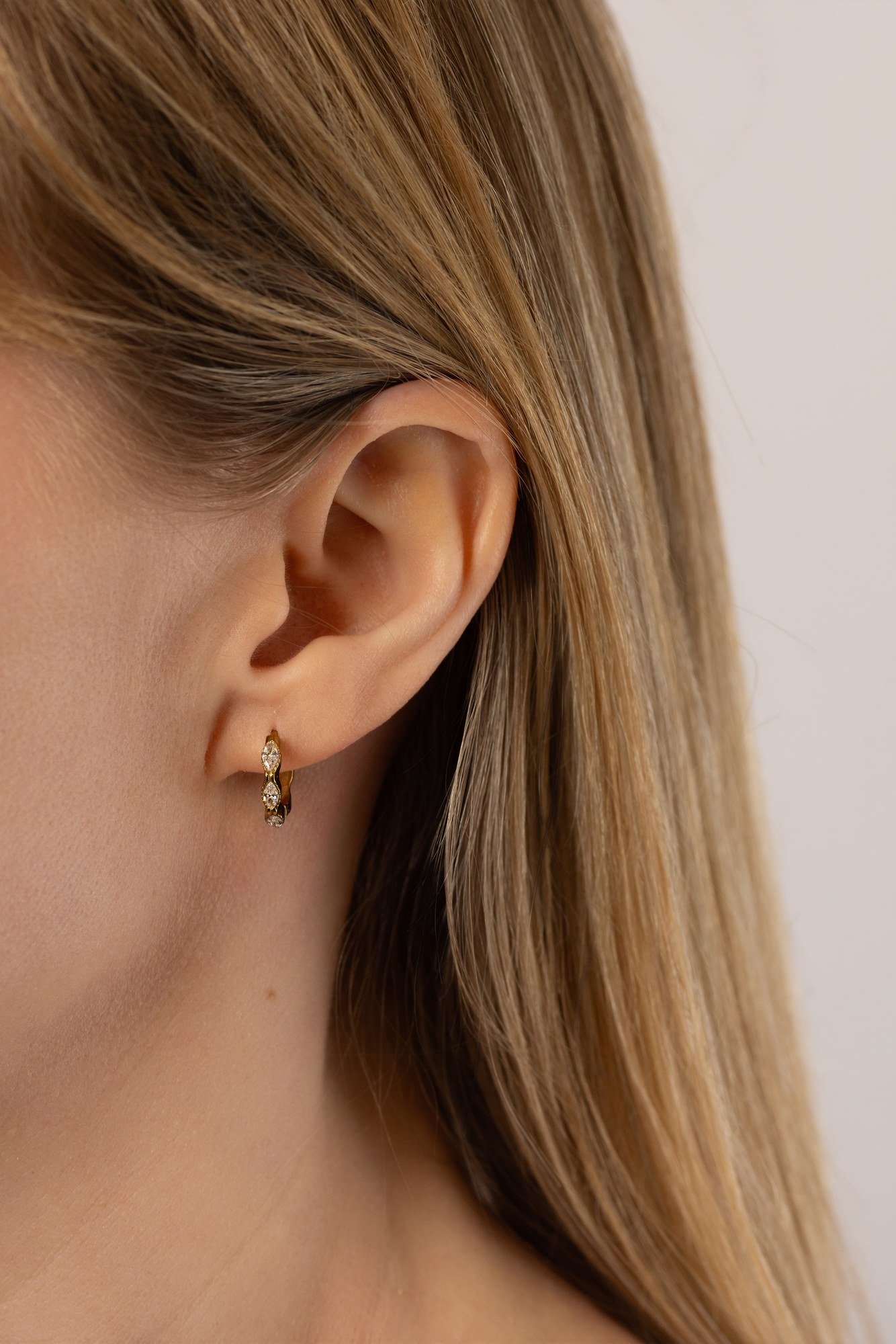 House Thirteen Luna Huggie Earrings worn on model, gold CZ set huggie hoop earrings