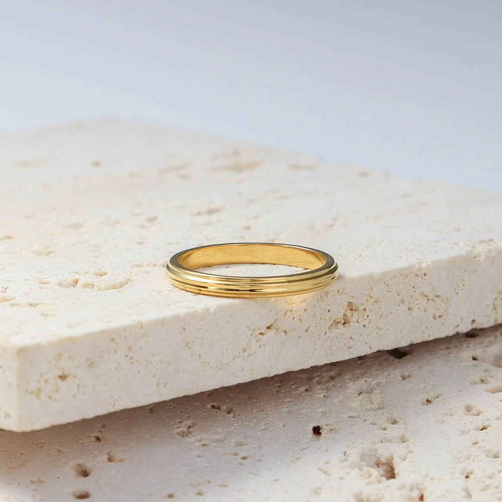 House Thirteen Ridge Stacking Ring in gold styled on travertine stone. Stackable ridged gold band with a minimalistic feel