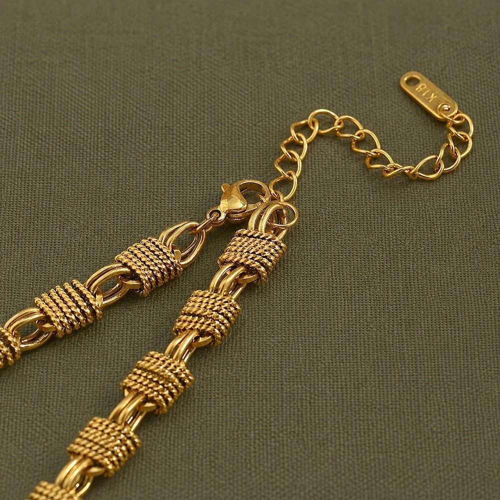 ouse Thirteen Woven Chunky Chain Necklace. Close-up of lobster clasp and woven link detail in gold PVD stainless steel