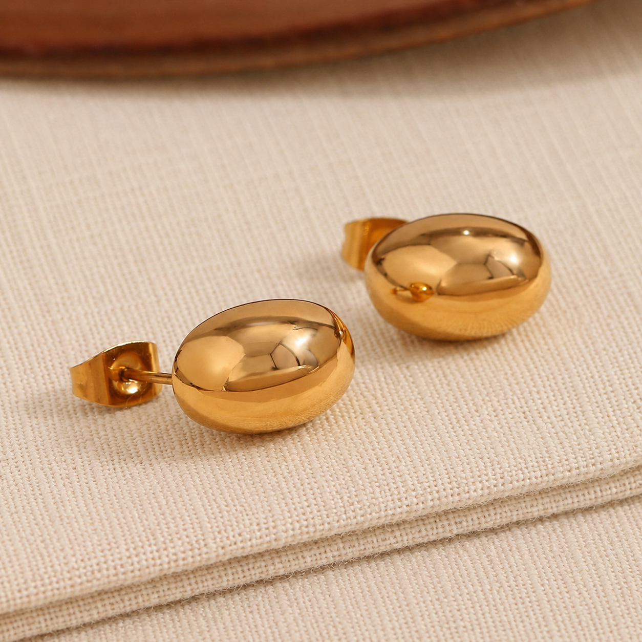 House Thirteen Bubble Stud Earrings on cream linen showing butterfly back, waterproof gold oval stud earrings