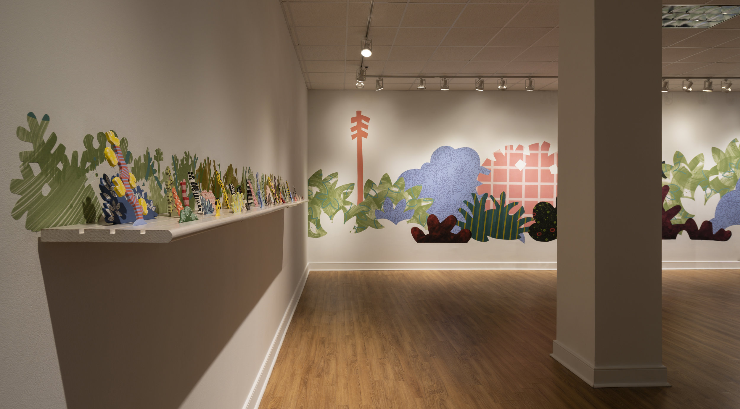  From right to left:     Piecemeal Promenade   (2019) 48ft x 11ft; latex on muslin cut-outs, adhered to wall;     Horizon Allsorts  , (2018) 12ft x 1ft; (6) floating wood shelves, painted muslin, ceramic, underglaze and glaze 