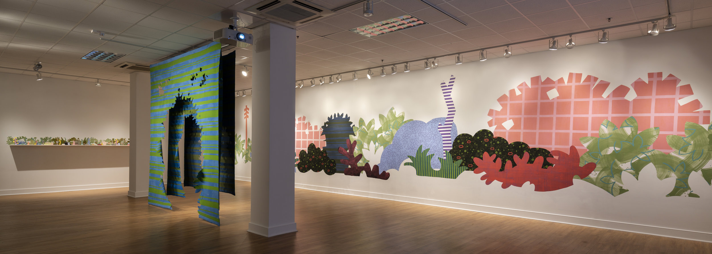 From right to left: Piecemeal Promenade (2019) 48ft x 11ft; latex on muslin cut-outs, adhered to wall; Proscenium Hedgerow (2018) 11ft x 10ft x 2ft; series of three latex on cut muslin panels; Horizon Allsorts , (2018) 12ft x 1ft; (6) floating wood shelves, painted muslin, ceramic, underglaze and glaze