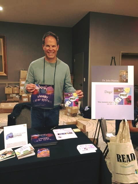 Founder Dr. John Hutton with two of his own blue manatee press titles, “Sleepy Solar System” and “Dogs!”