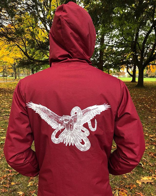 Our updated &ldquo;Osprey Battle&rdquo; jackets. White ink on a crimson, 100% waterproof hooded coaches jacket. These are great for layering on chilly fall days, or for keeping you dry on the slopes on those warm spring slush days. Hand-drawn and han