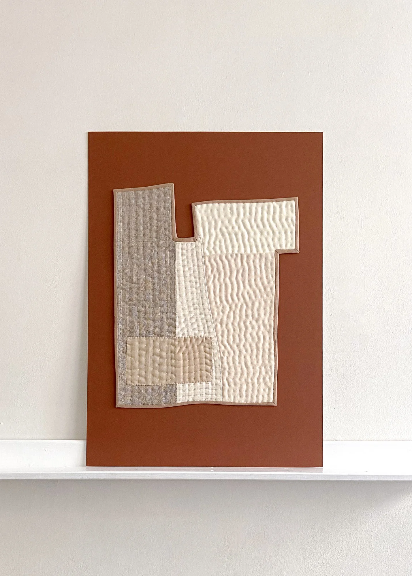 Quilted fragments of cloth creating abstract compositions which are mounted to board as artworks by House of Quinn