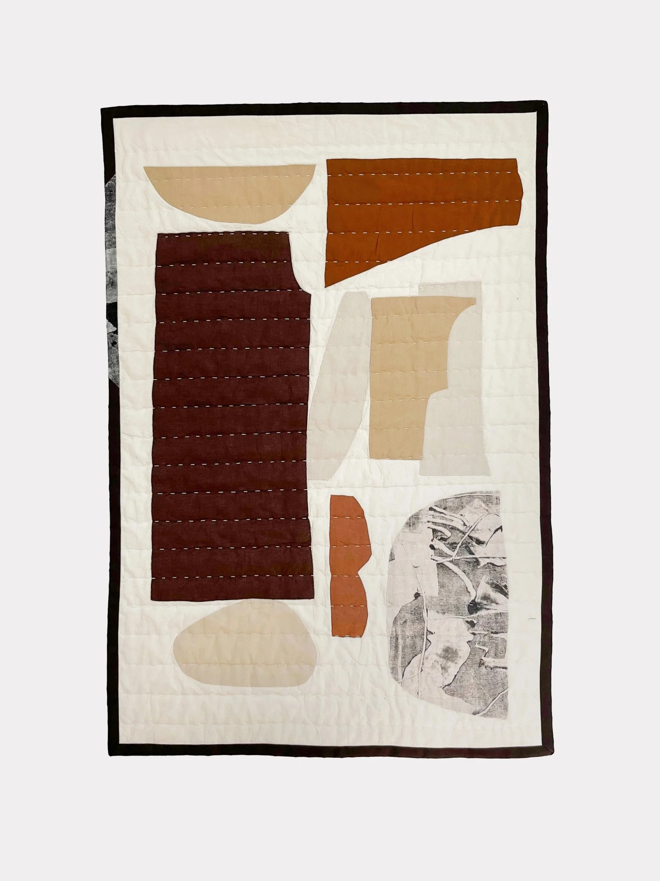 Abstract, quilted composition of hand printed textiles and linens to create a contemporary quilt by House of Quinn