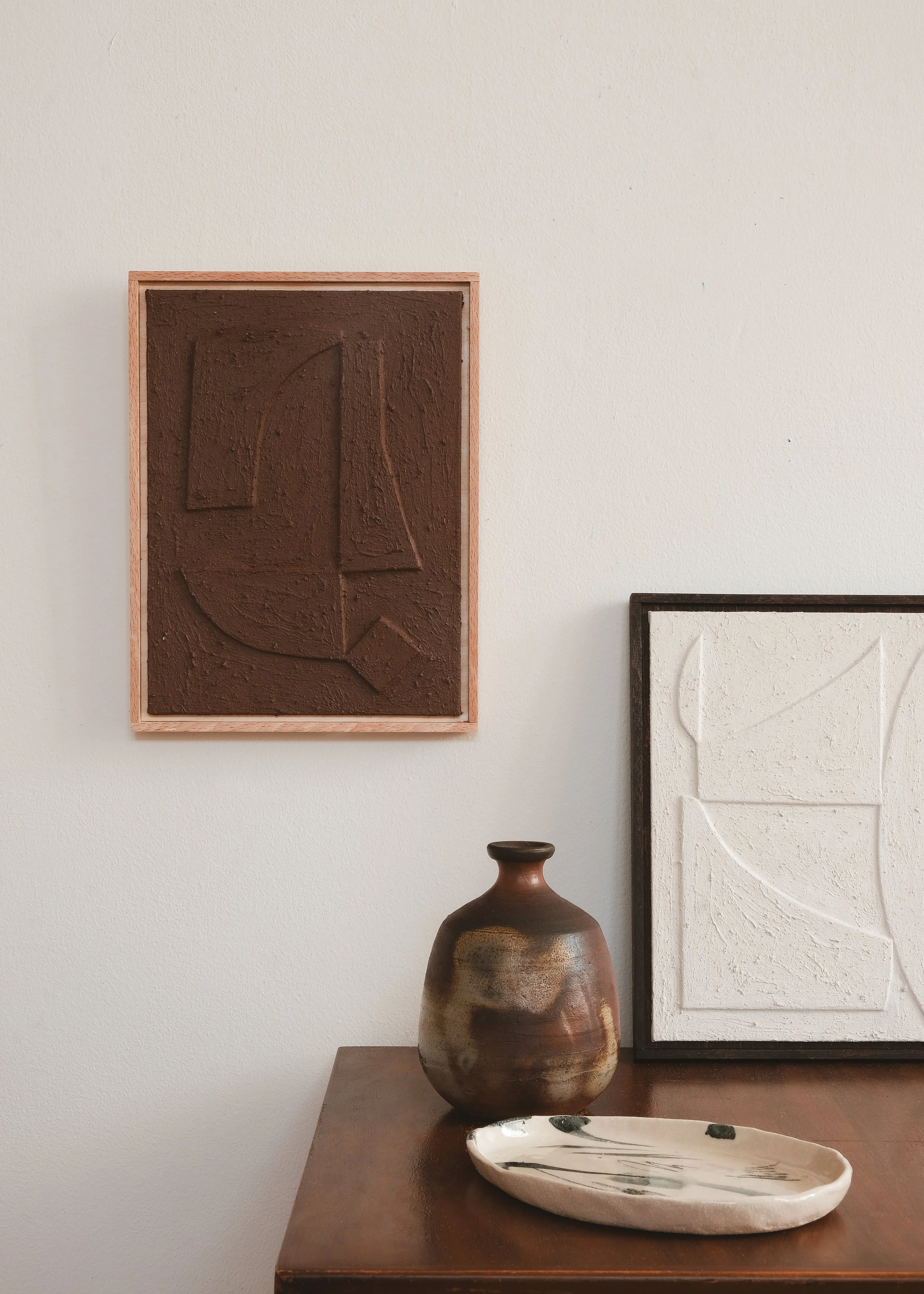 Caer xvi in Clay. Abstract relief paintings by House of Quinn. Featured in a minimalist interior setting.