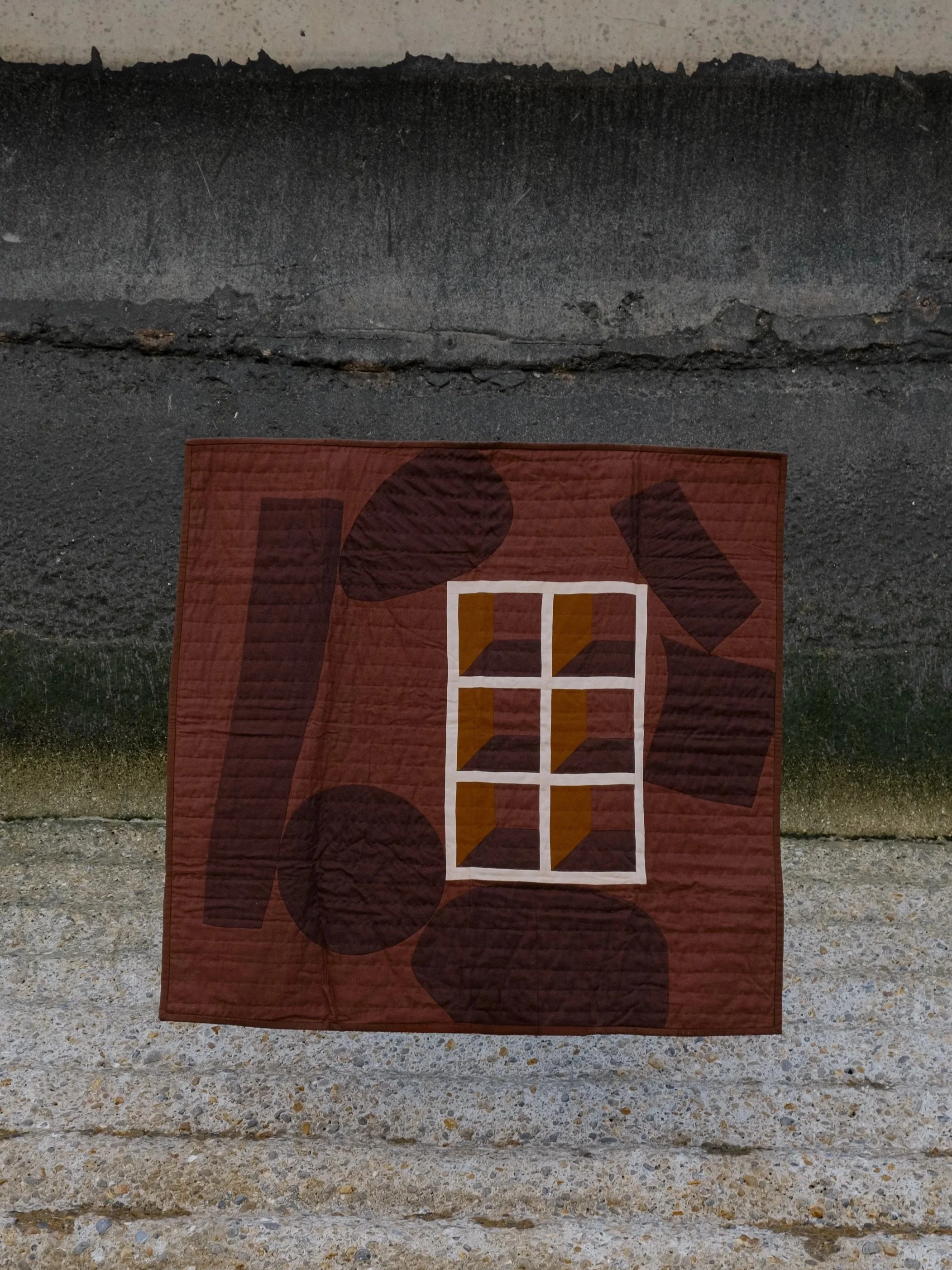 Abstract Quilt by House of Quinn, dark brown abstract forms are arranged around a central geometric window pane quilt block