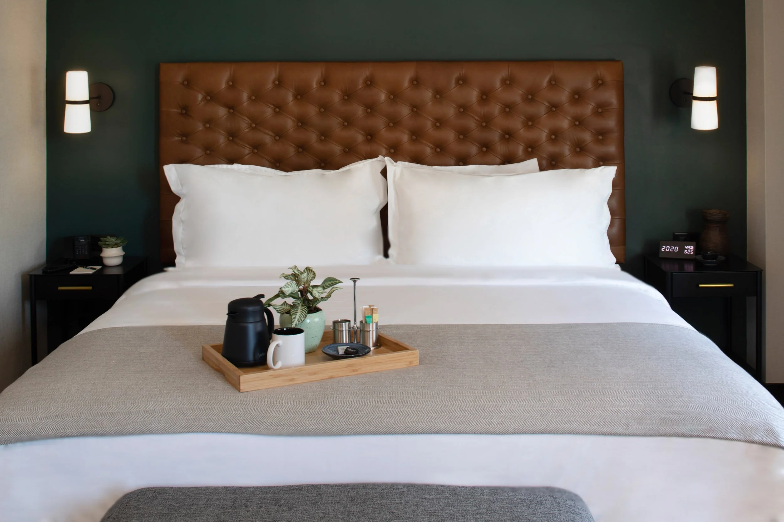 Hotel-style bedroom with upholstered headboard, neutral tones, and styled bedside details photographed in Connecticut