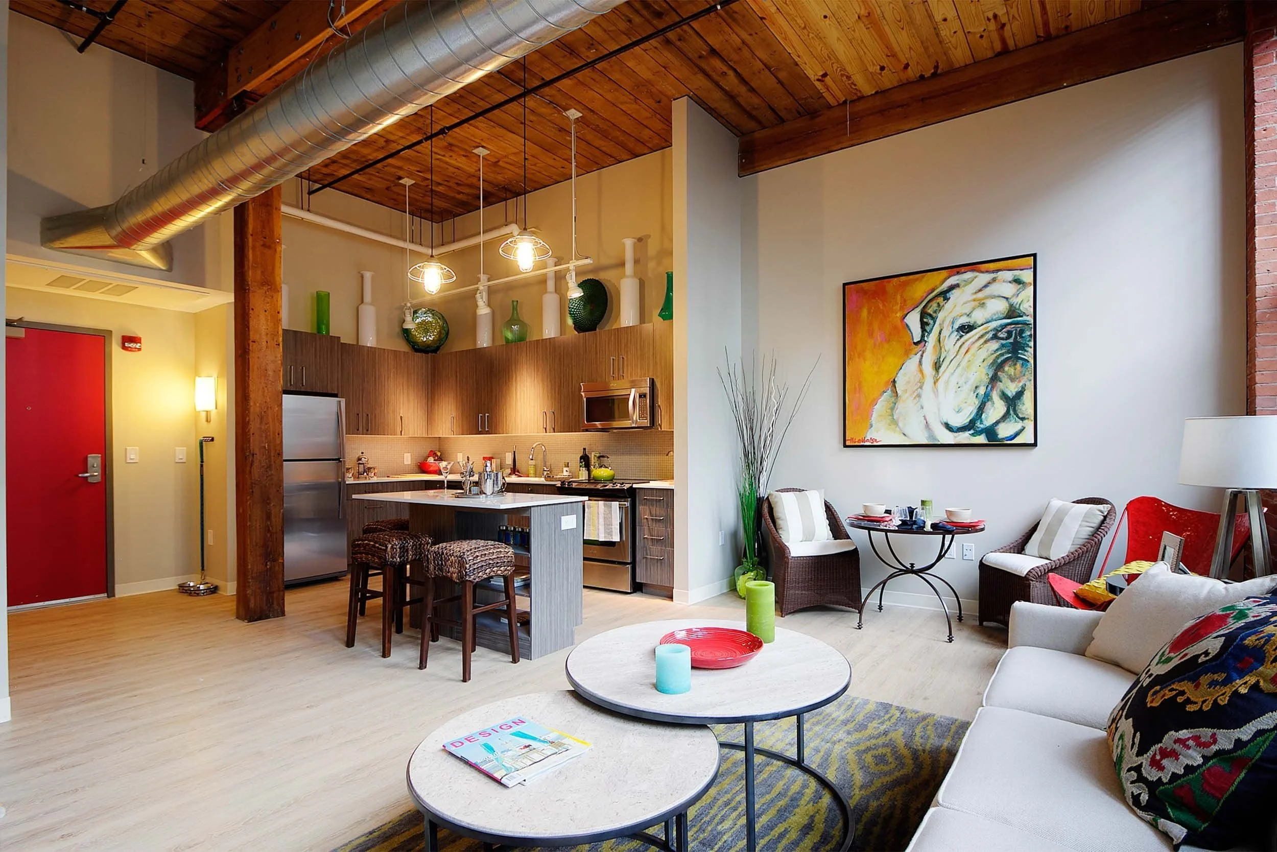 Open-concept loft apartment with exposed wood ceiling, kitchen, and living area photographed in Connecticut