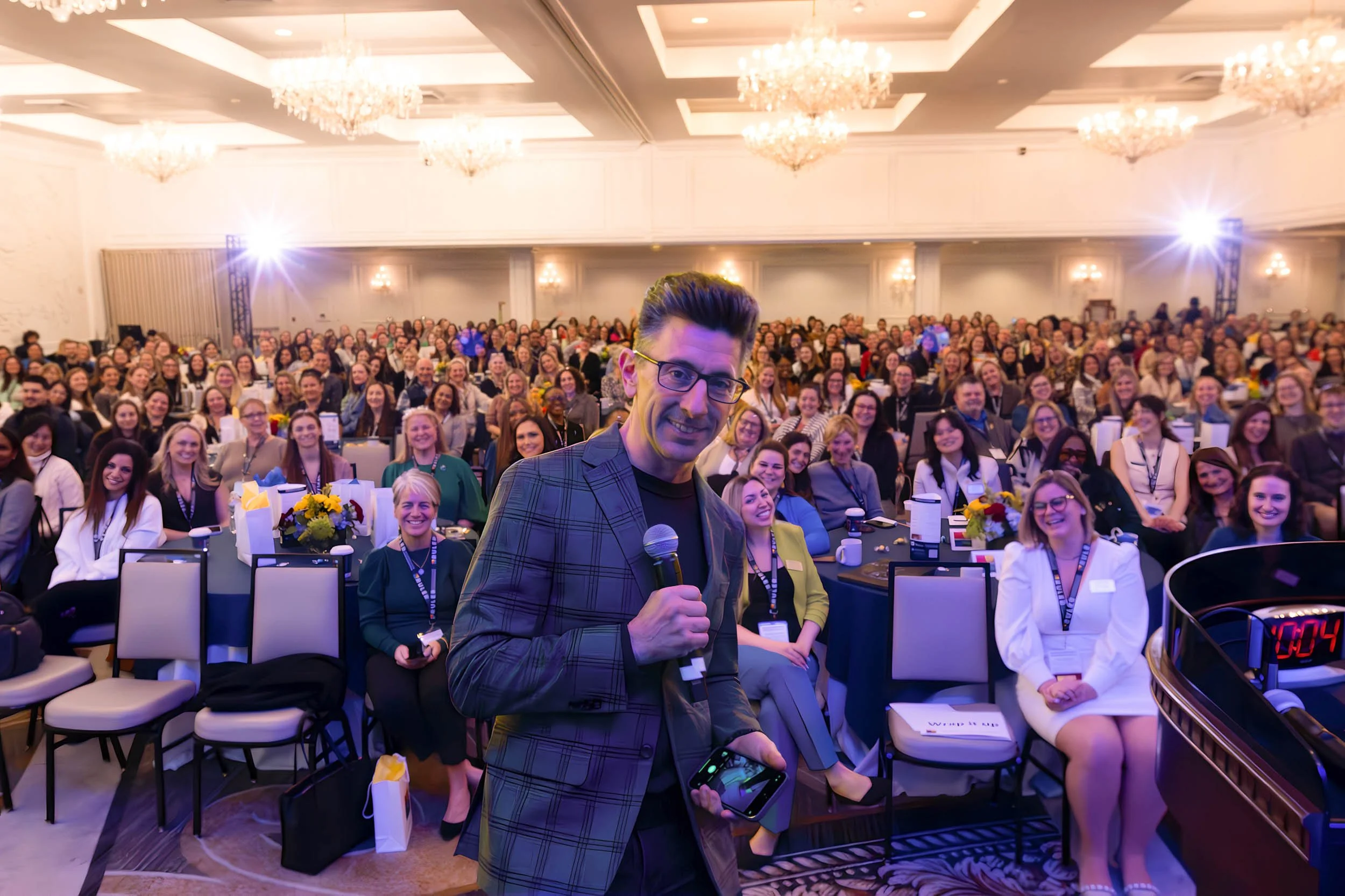 Keynote speaker addressing a large audience at a professional conference in Connecticut
