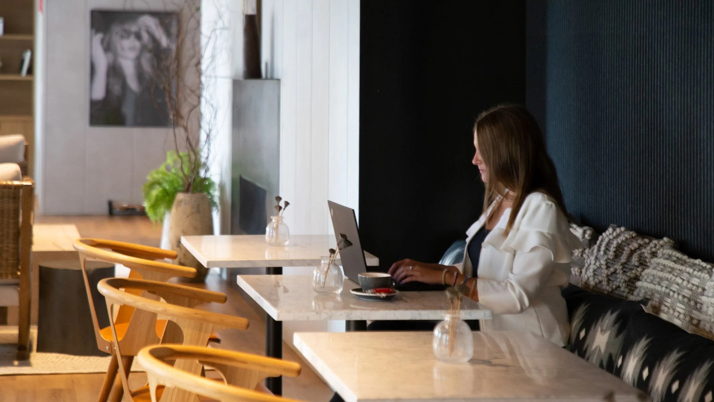 Professional woman working on a laptop in a modern café, photographed for business and editorial use in Connecticut