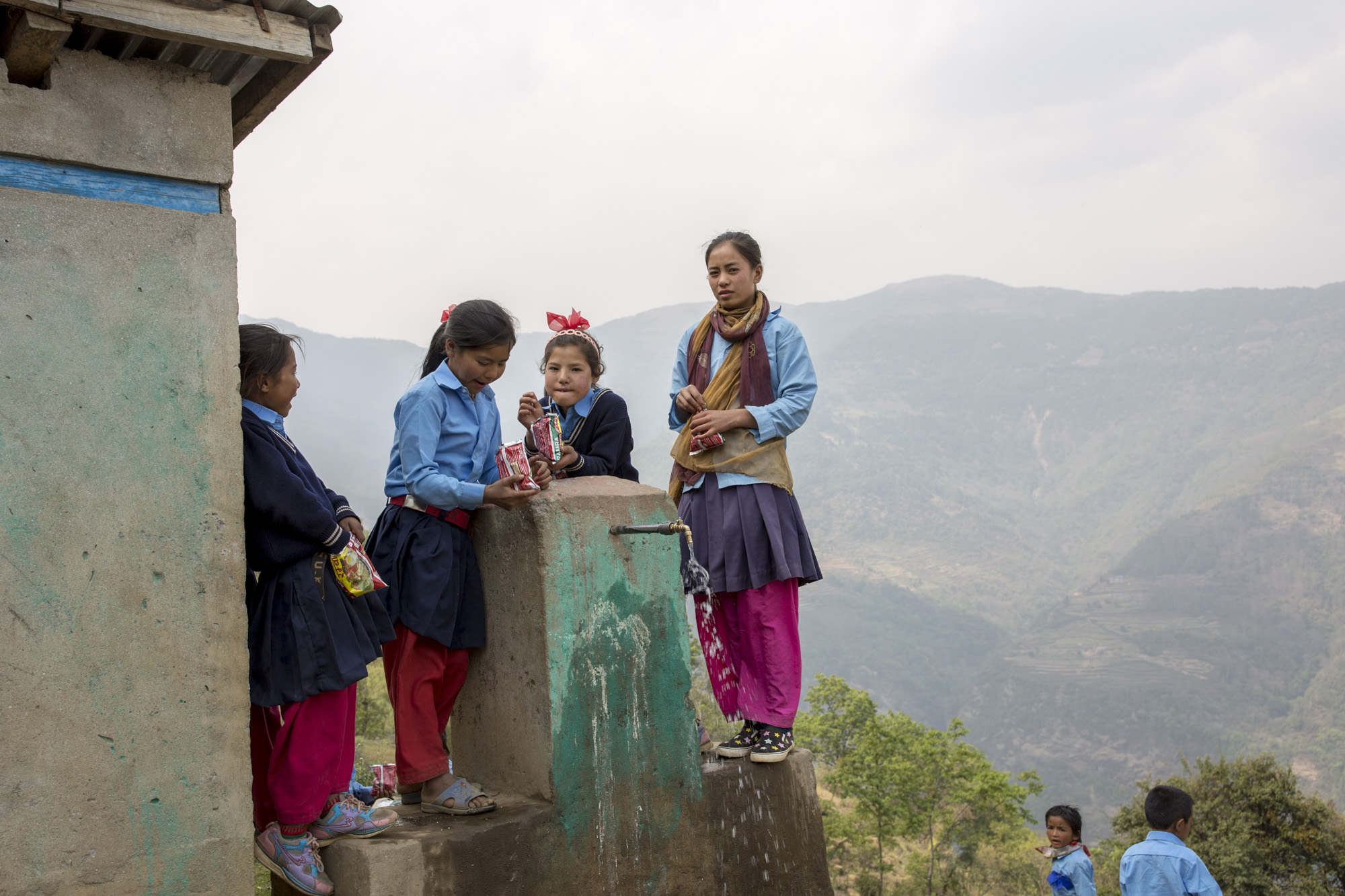 School girls gather around a drinking fountain