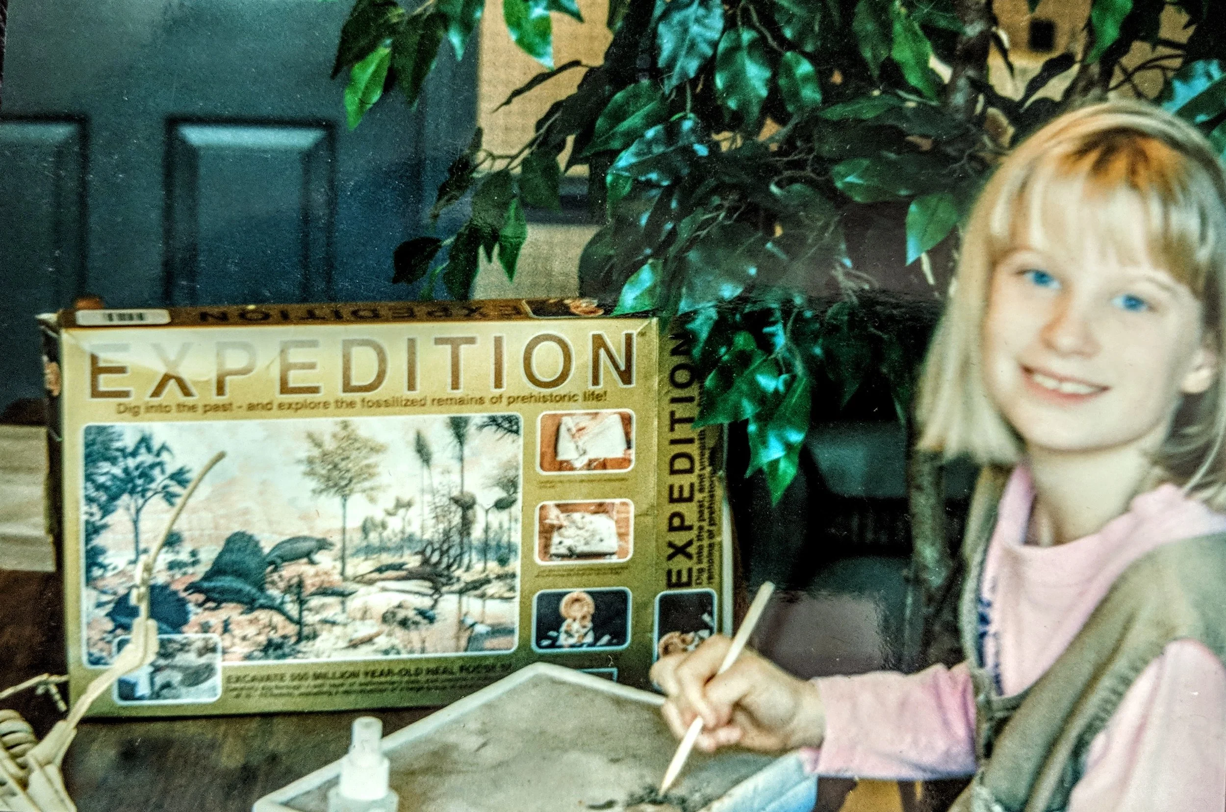 Shelbi, circa second grade, hunting for dinosaur fossils at the kitchen table.